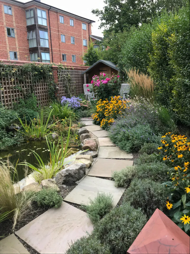 Planted garden borders beside a path in a Yorkshire garden