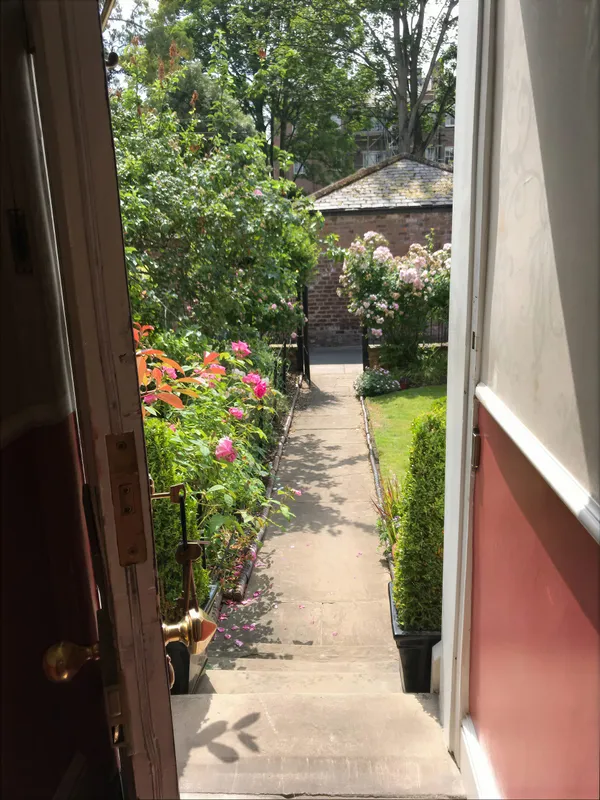 A narrow walled garden path edged with flowers