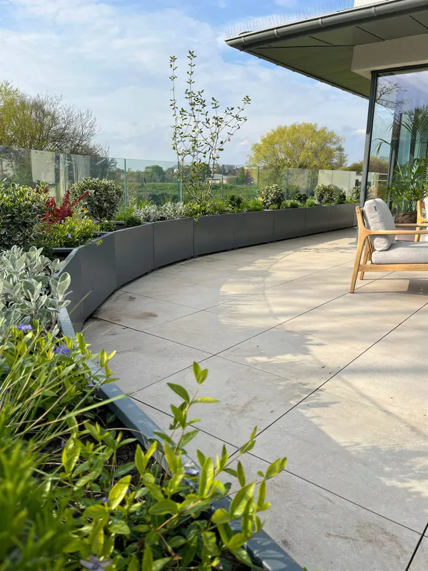 A contemporary paved terrace with modern planting
