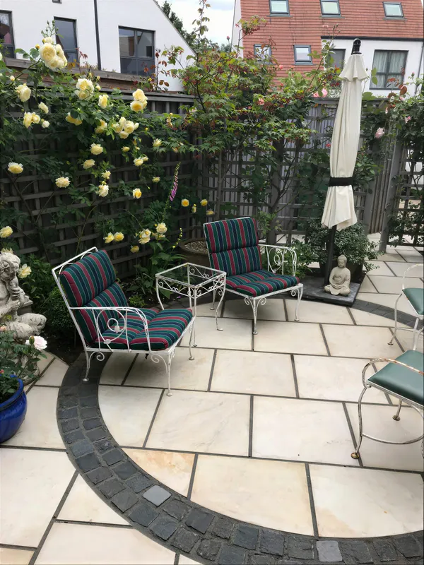 A paved garden seating area with a chair