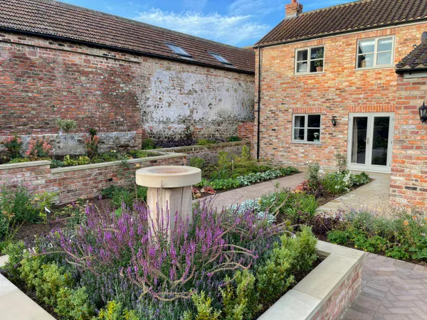 Stone bird bath surrounded by lavender which is great for bees.