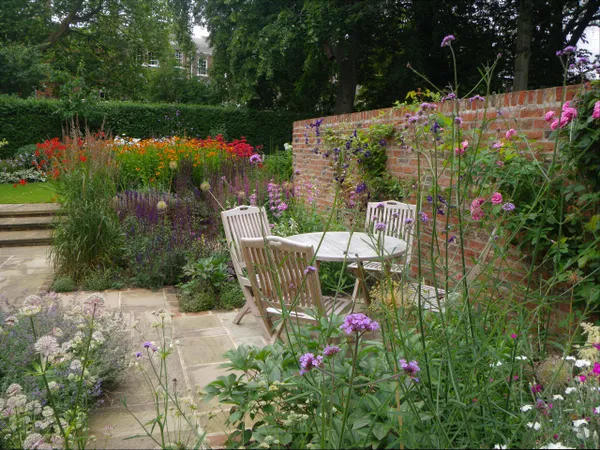 A paved terrace with seating, surrounded by planting