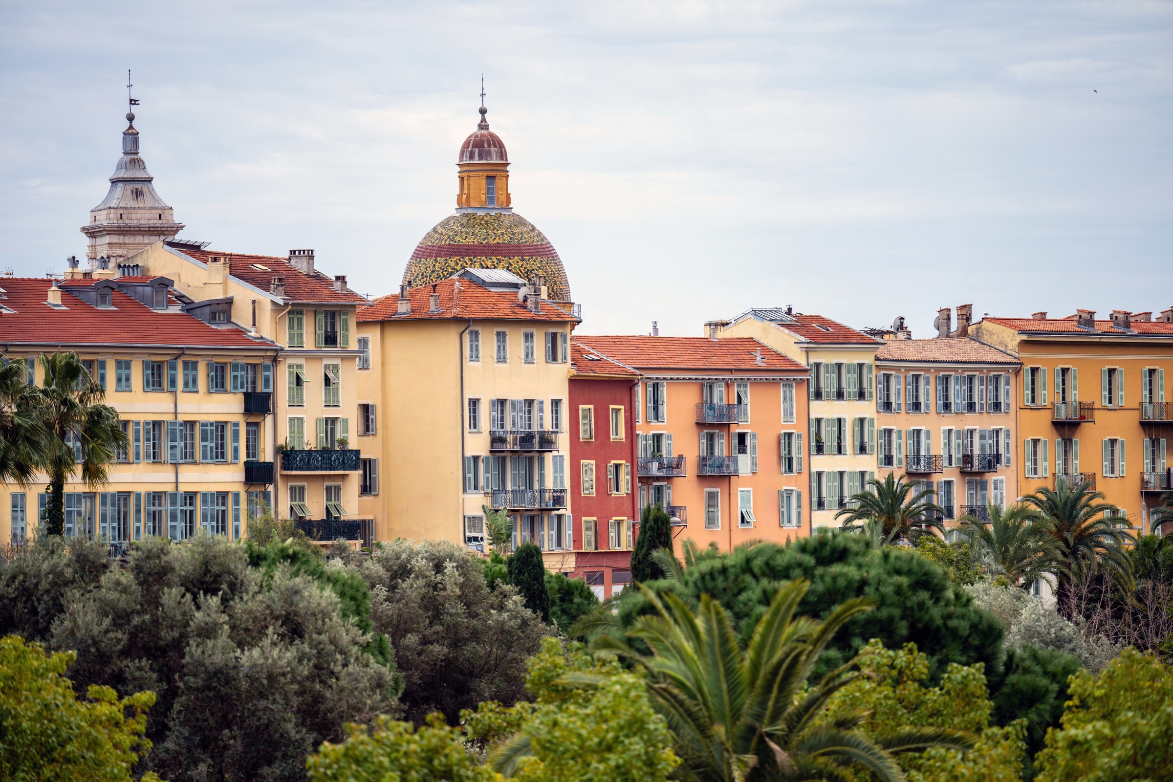 Palazzi gialli e arancio con tetti in coppi tra le palme