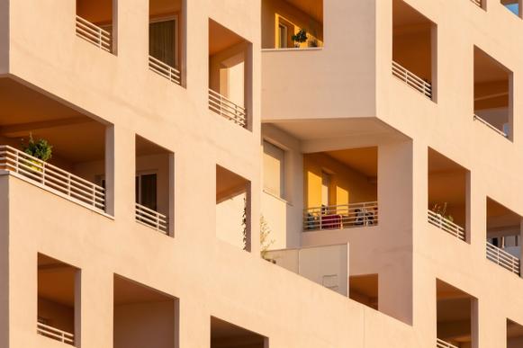 Loggien einer cremefarbenen Fassade im Abendlicht