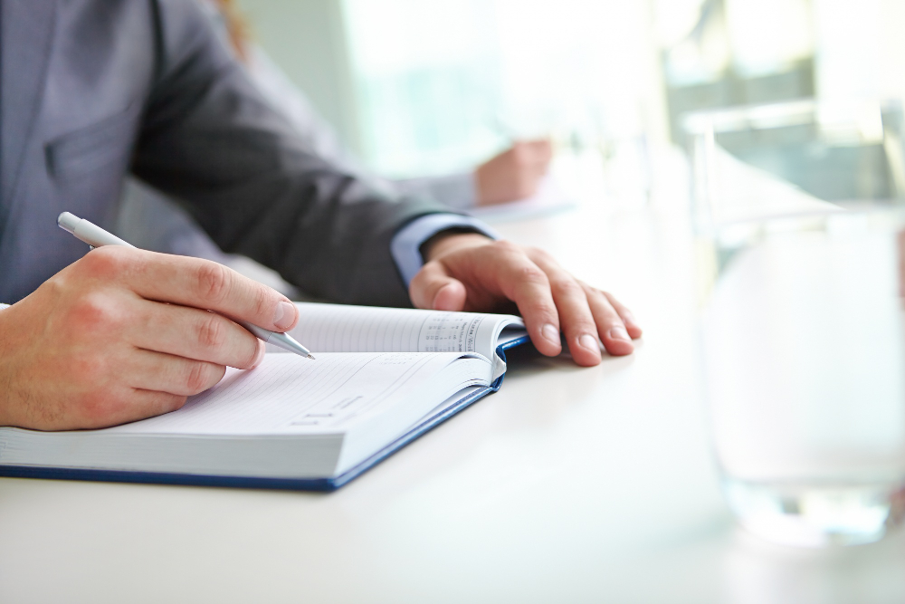 amministratore alla scrivania scrive sull'agenda
