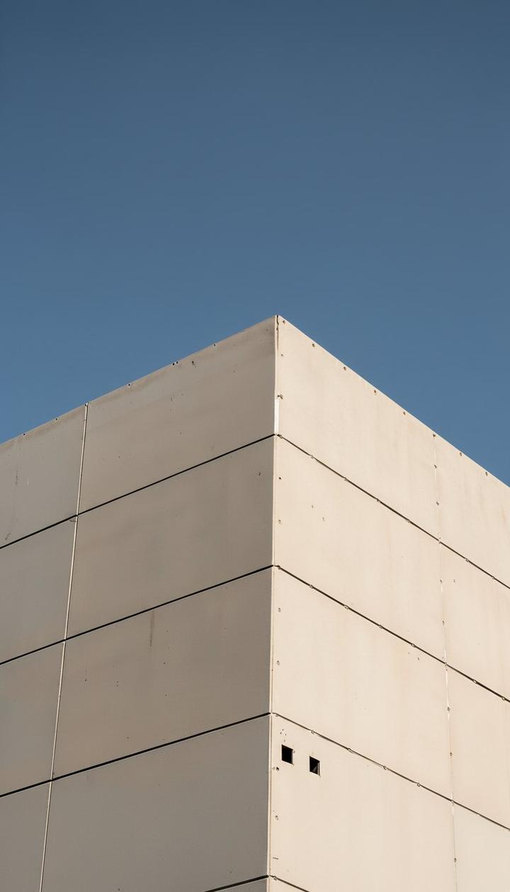 Betonecke mit Plattenfugen gegen den Himmel