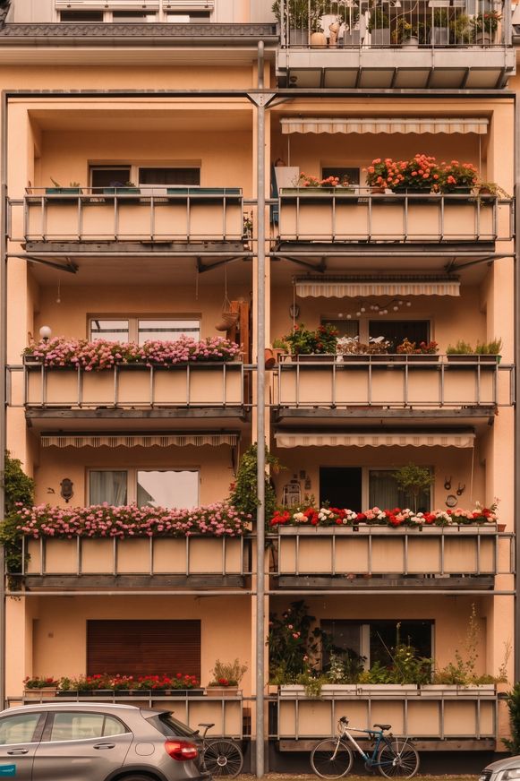 Apricotfarbene Balkone mit Blumenkaesten im warmen Licht