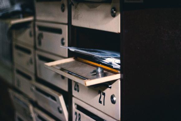 Cassette delle lettere di un condominio, una aperta con la posta all'interno