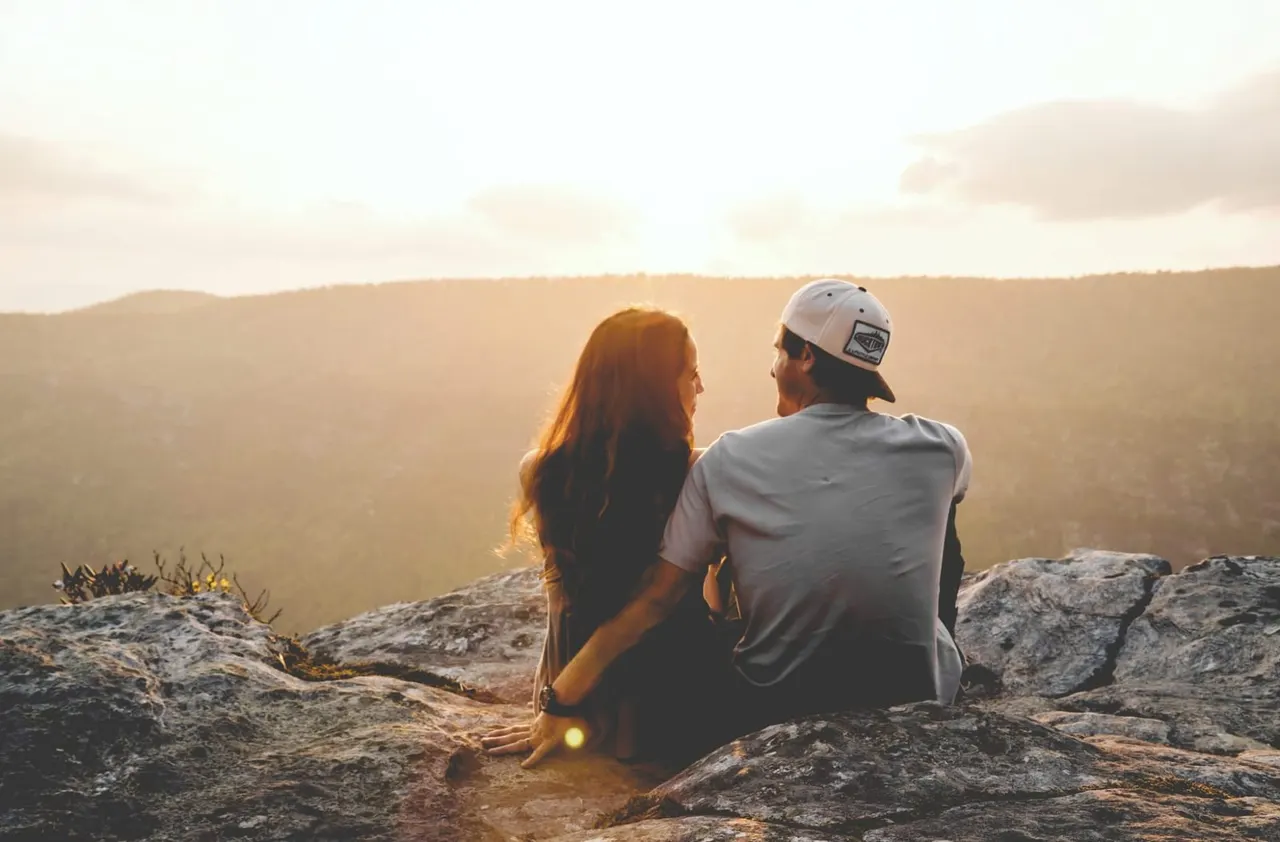 Couple watching the sunset together on a rocky outlook