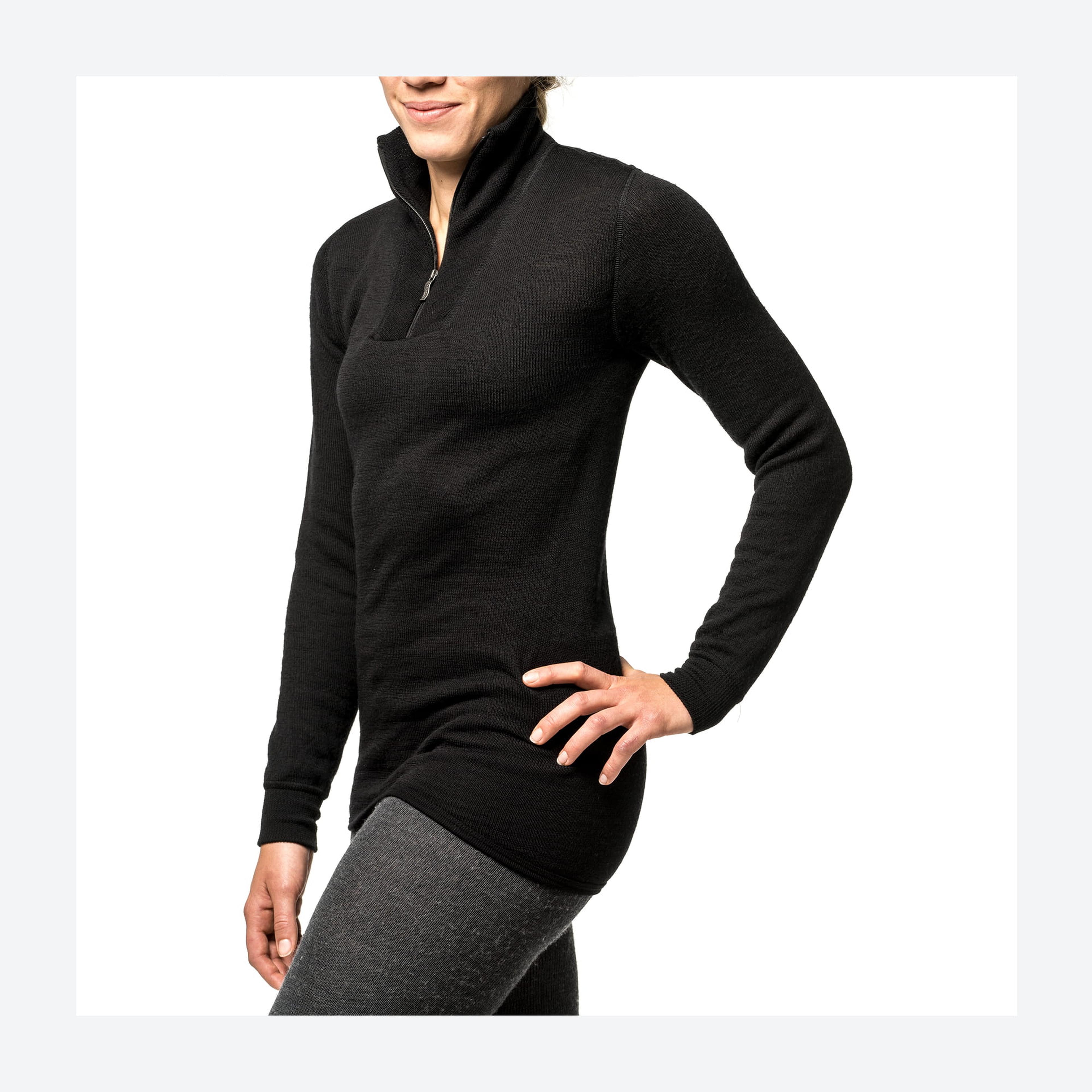 Person wearing a black long-sleeve fleece top with a half-zip and standing with one hand on their hip, set against a plain white background.