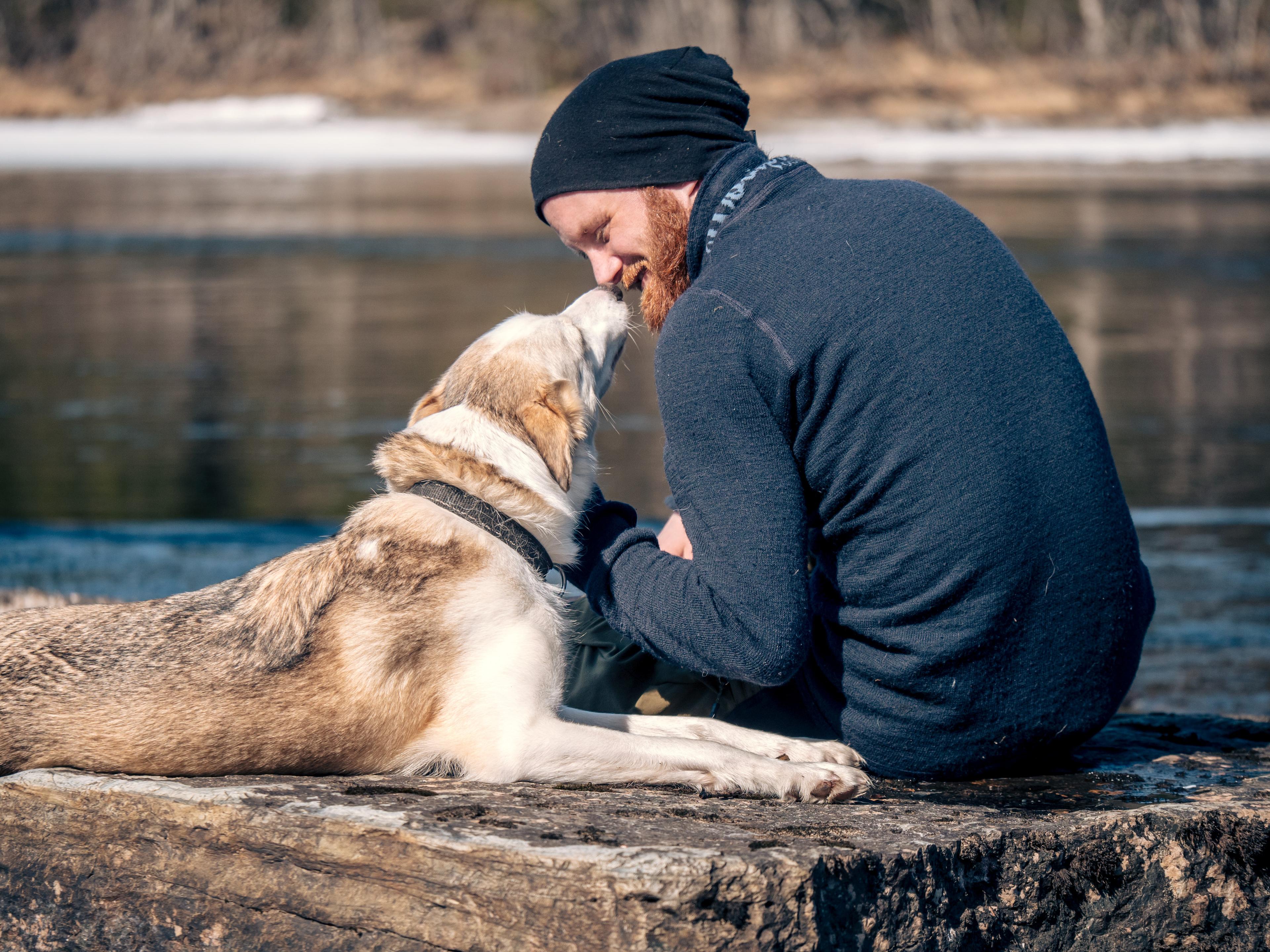 A man and his dog looking out a body of water.
