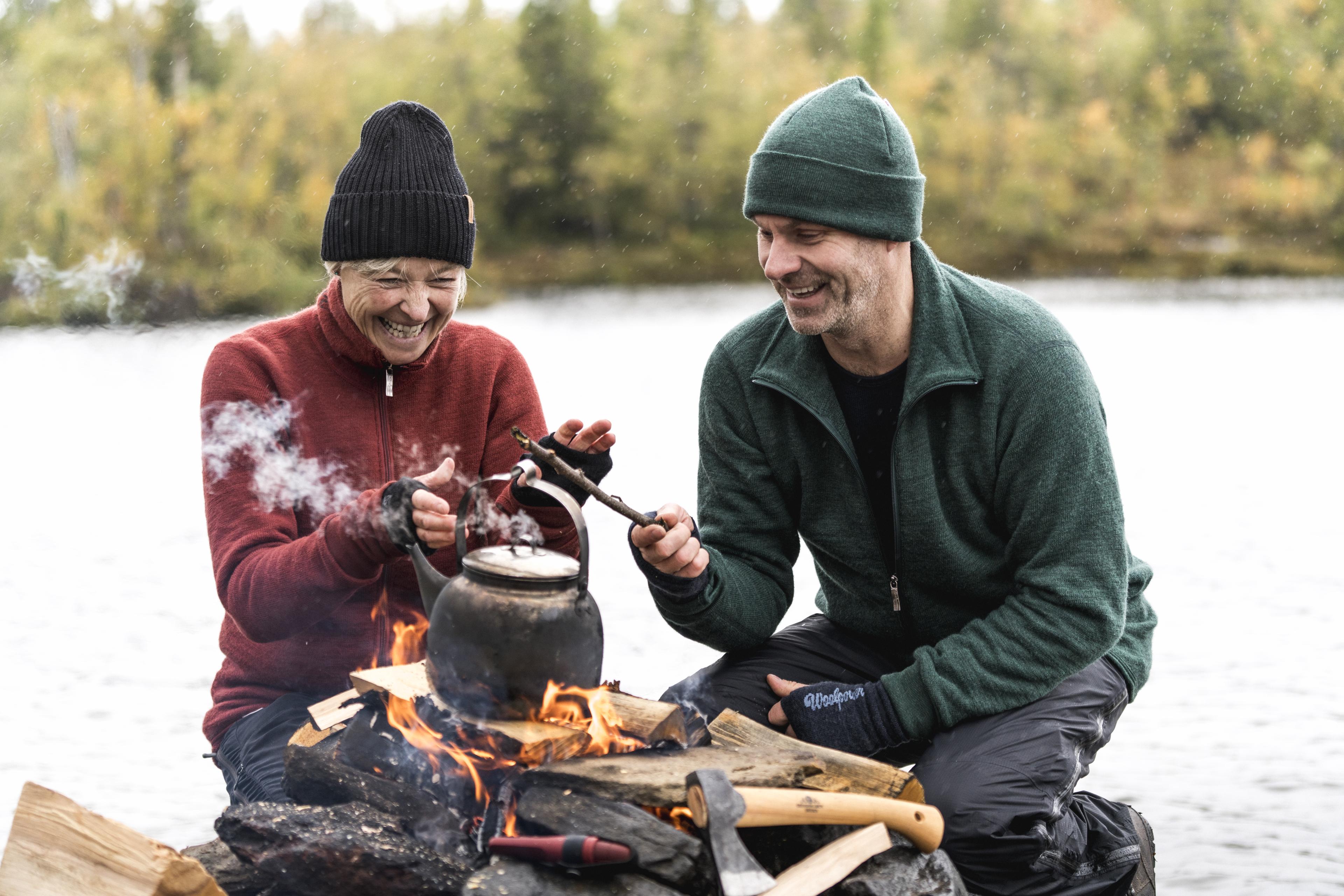 Couple enjoying a campfire, dressed in Full Zip Jacket 400 jackets in Red and Forest Green