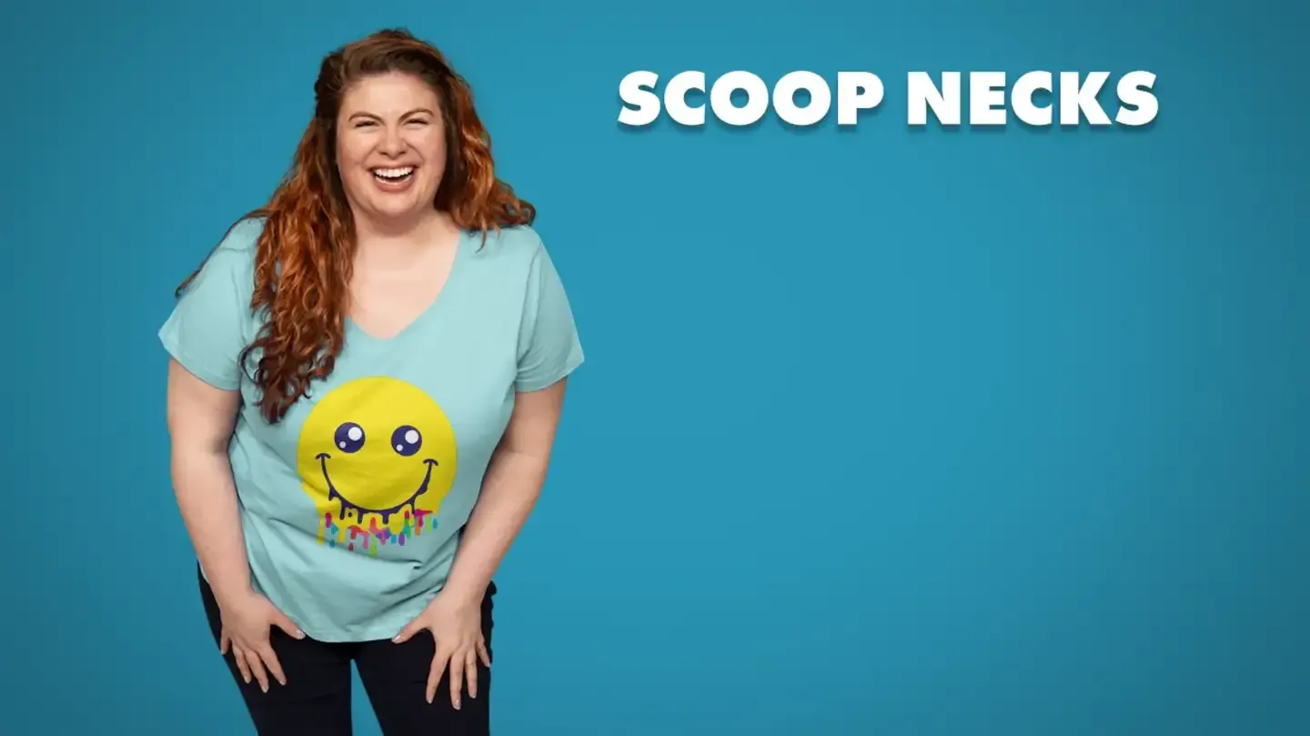 Smiling woman in mint women's scoop neck t-shirt with dripping yellow smiley face graphic on blue backdrop.
