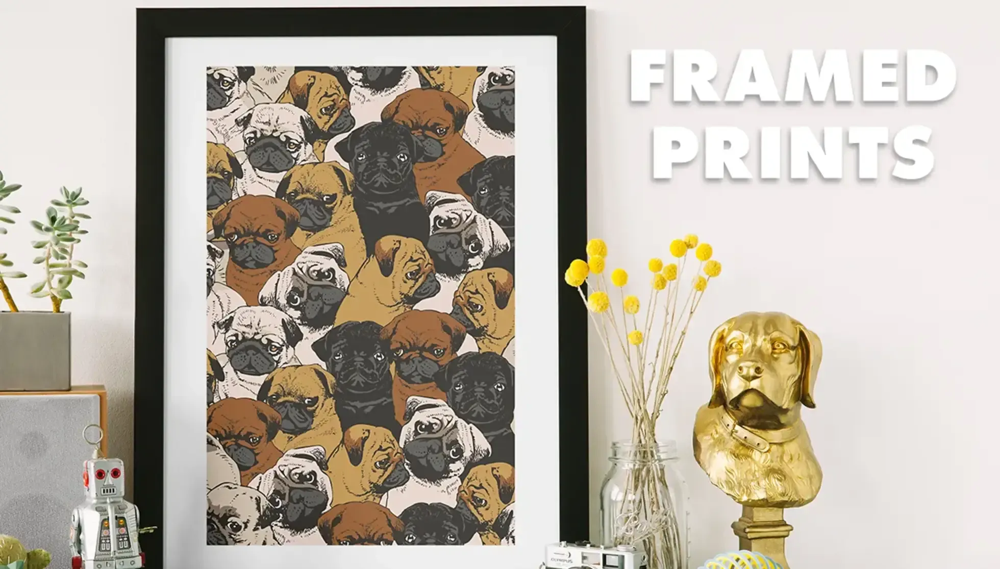 Large framed print of pug-faced dogs pattern on shelf with vase of yellow flowers labelled 'Framed Prints'.