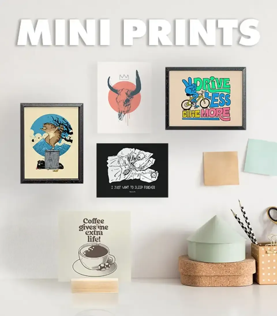 Mini framed prints arranged on white wall with desk and stationery, labelled 'Mini Prints'.