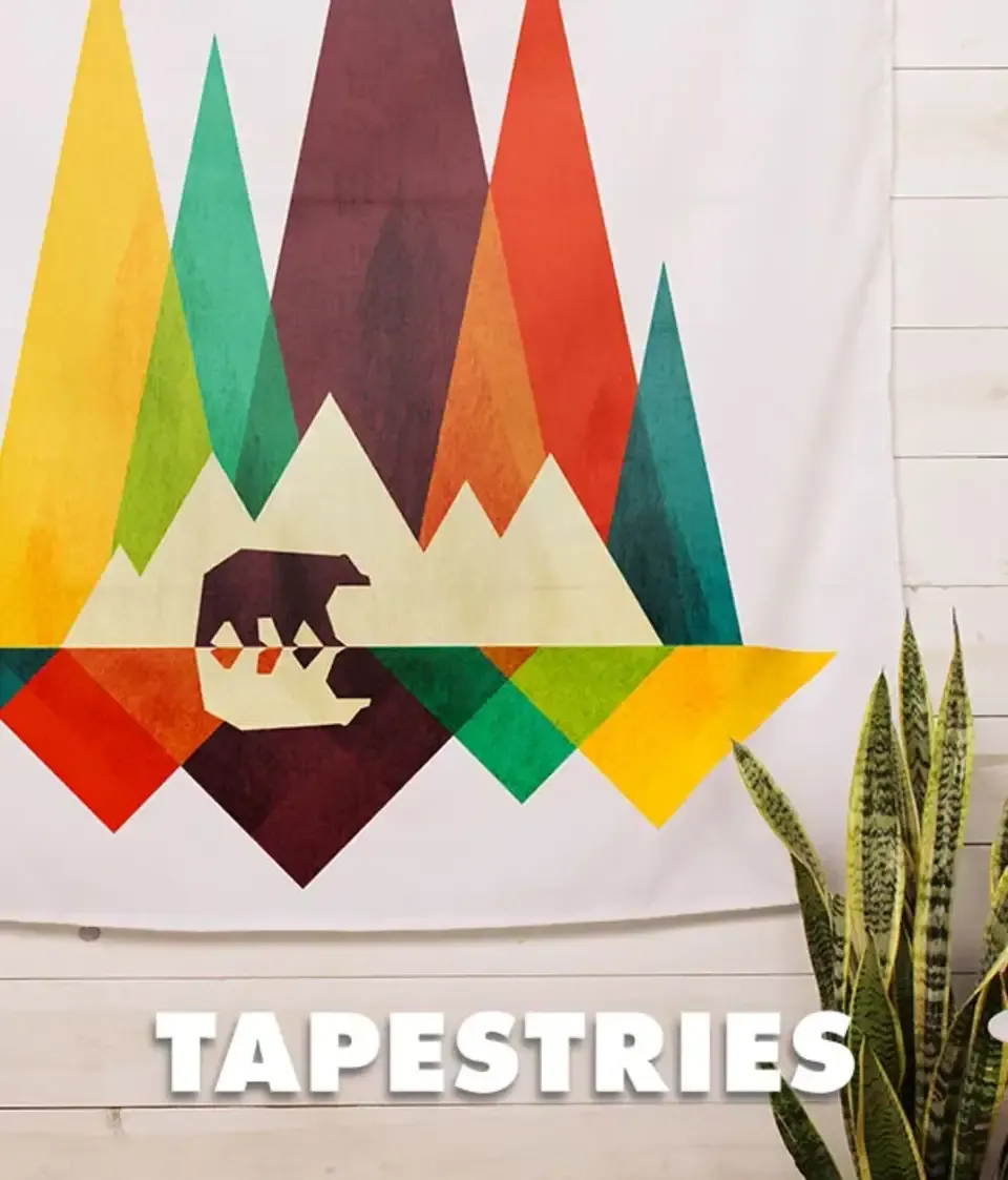 Colorful triangle mountains and bear tapestry on wall next to snake plant with 'Tapestries' text.