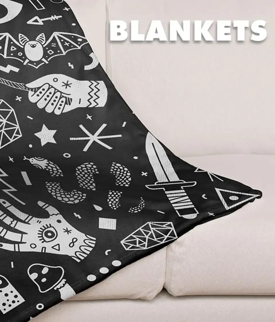 Black and white doodle pattern throw blanket draped on white sofa labelled 'Blankets'.