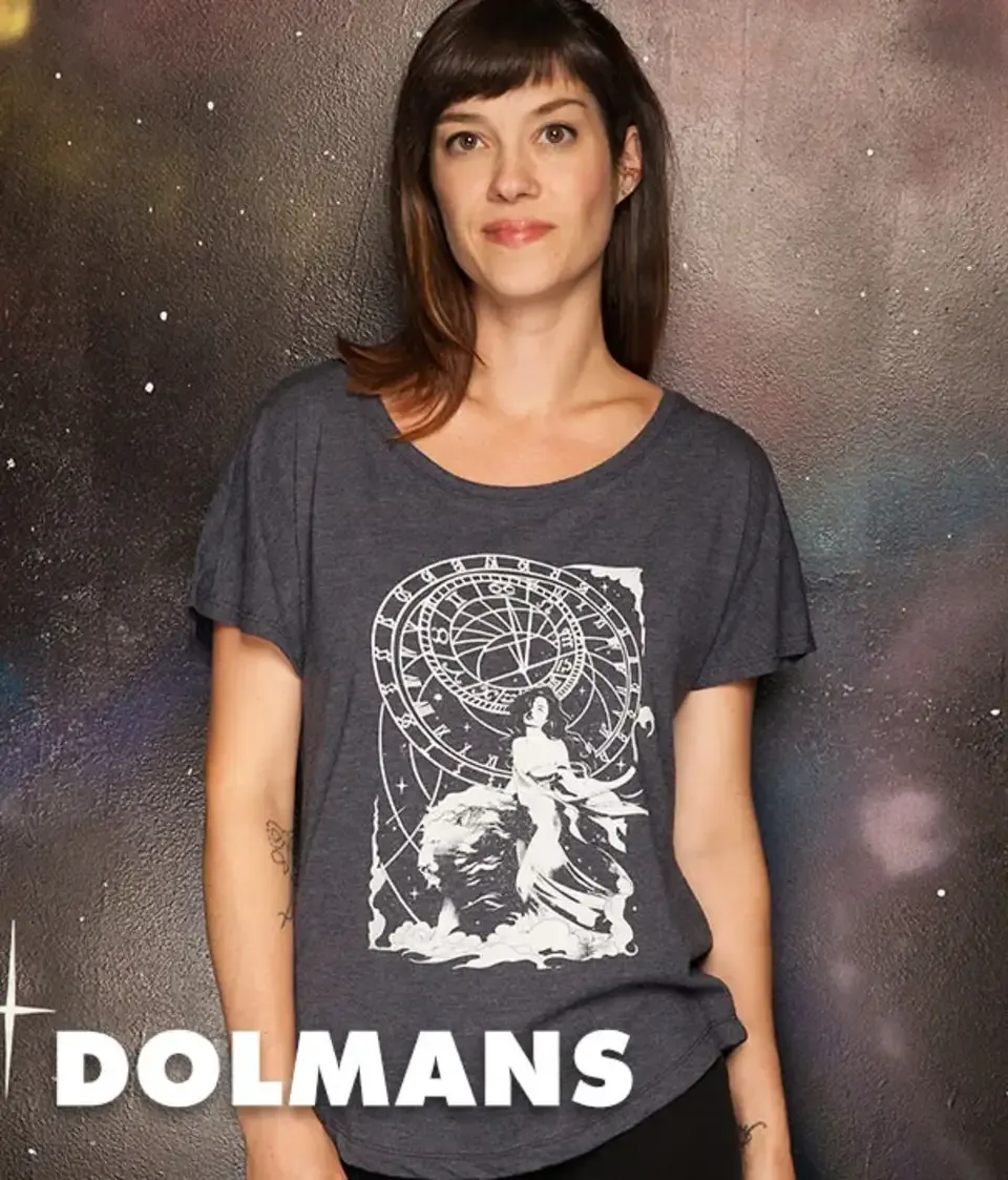 Woman in dark gray women's dolman t-shirt with white astrology zodiac wheel graphic on dark galaxy backdrop.
