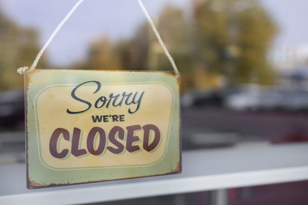 Cartello "sorry, we're closed" appeso sulla porta di un ristorante, ferie e permessi HoReCa.