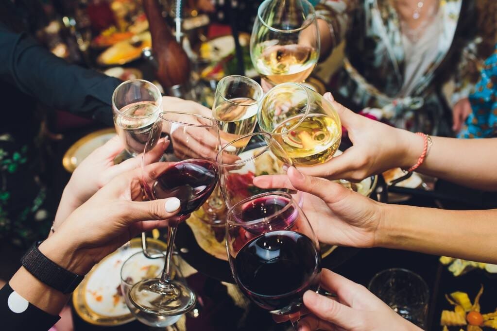 Brindisi con calici di vino. Consumo di alcolici alla guida, codice della strada e ristorazione
