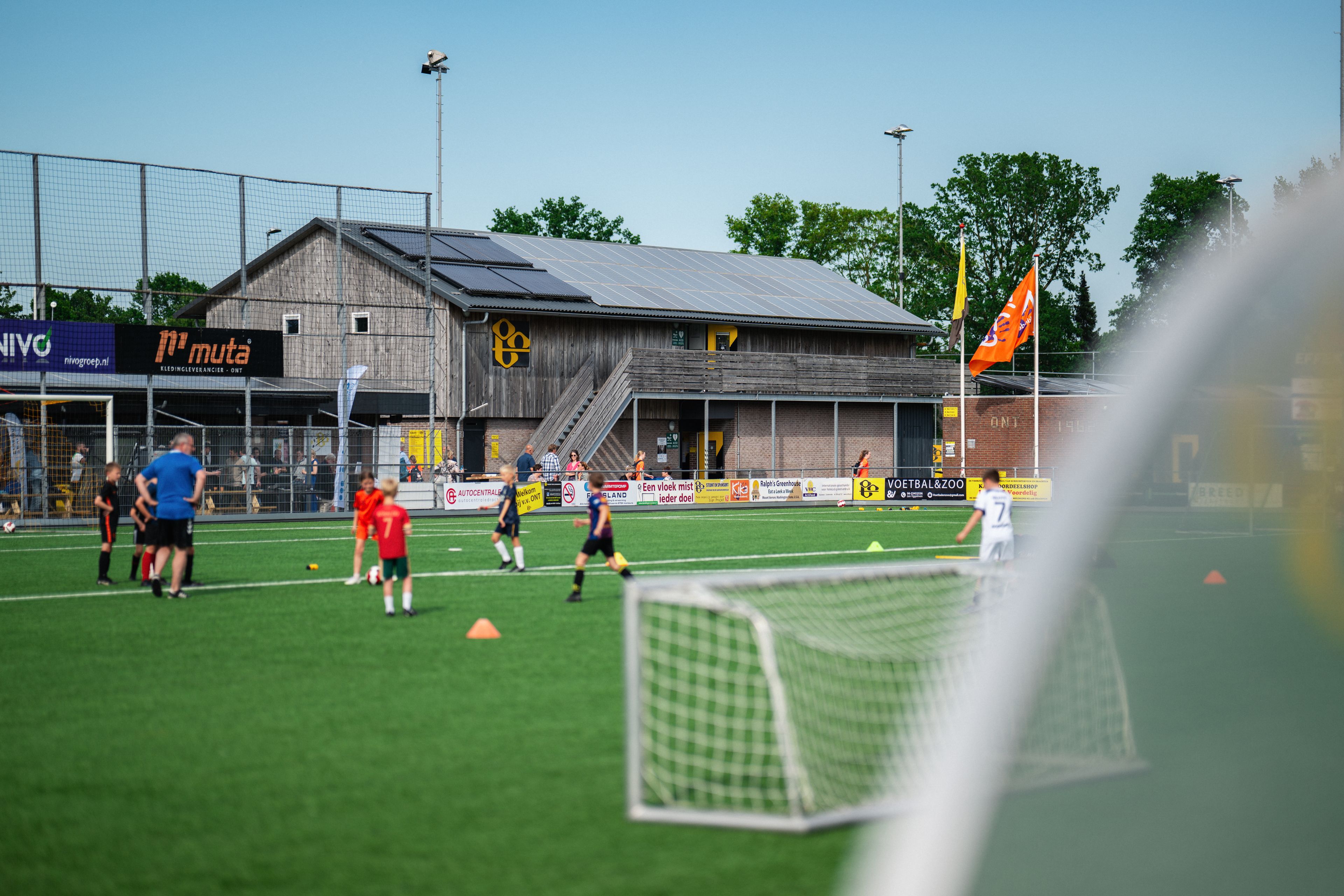 Voetballende kinderen op voetbalveld