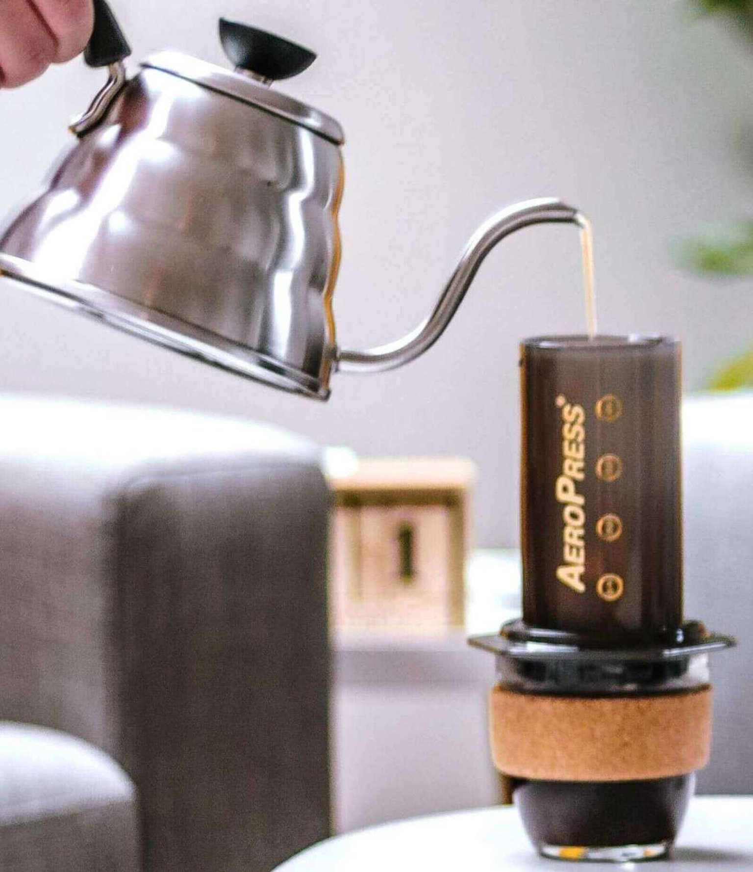AeroPress coffee maker brewing a clean, smooth cup on a wooden countertop.