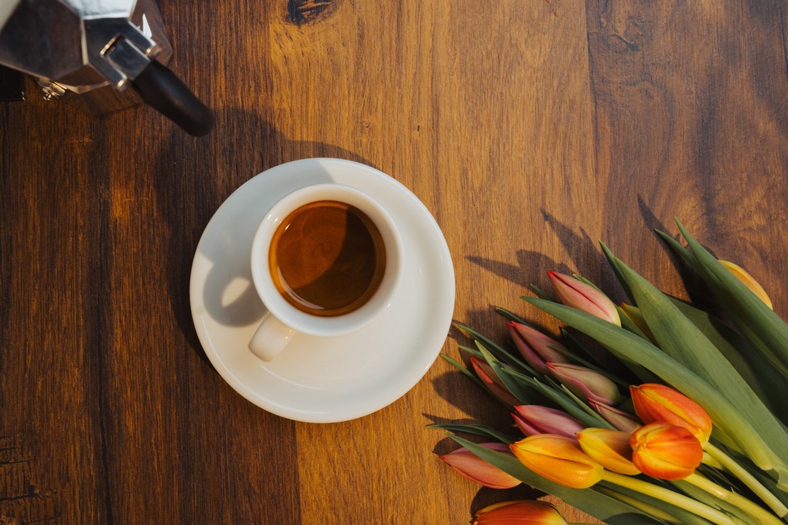coffee cup with tulips on a wooden table