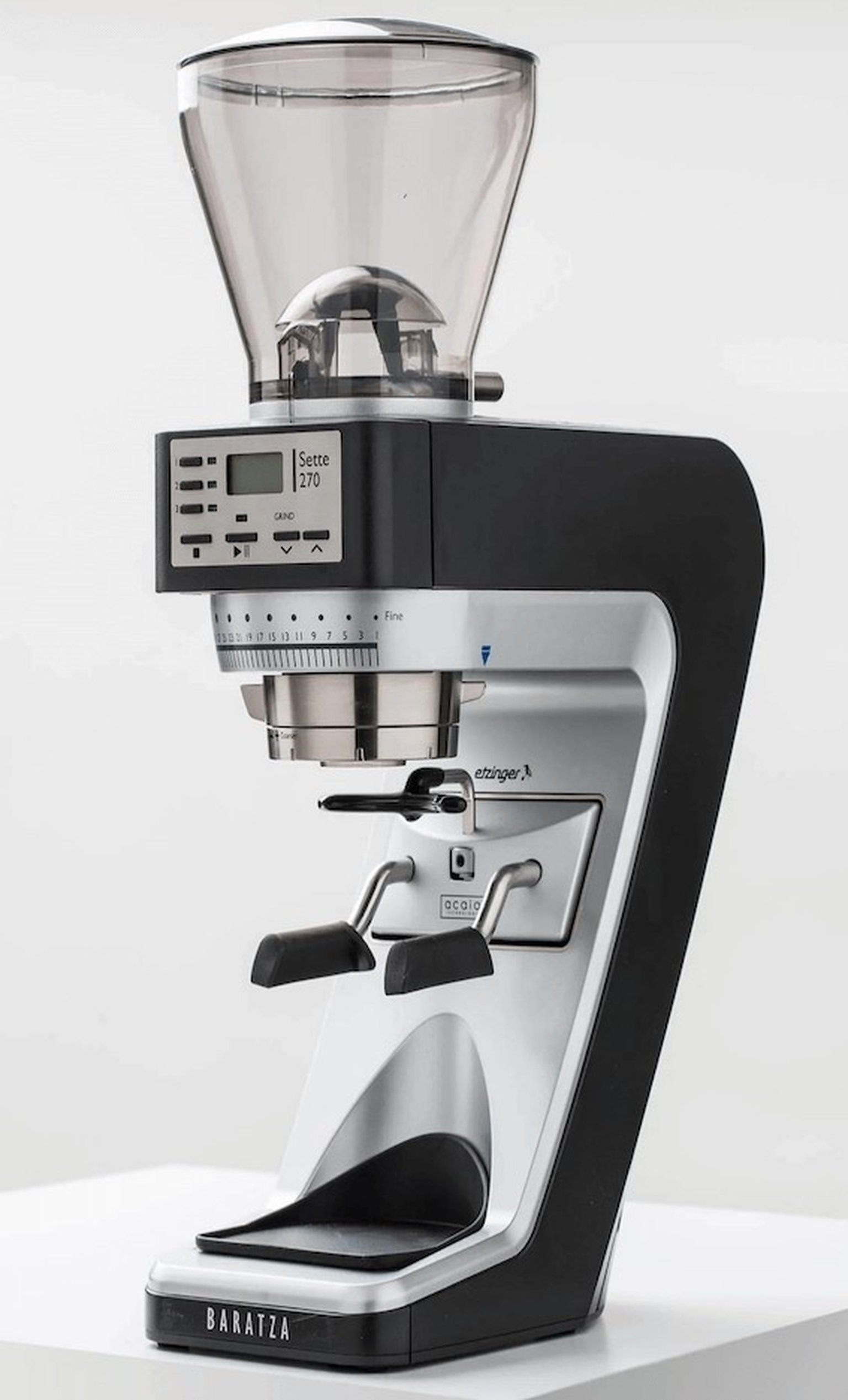 A hand uses a wooden-handled tamper on coffee grounds in a portafilter on a wooden countertop.
