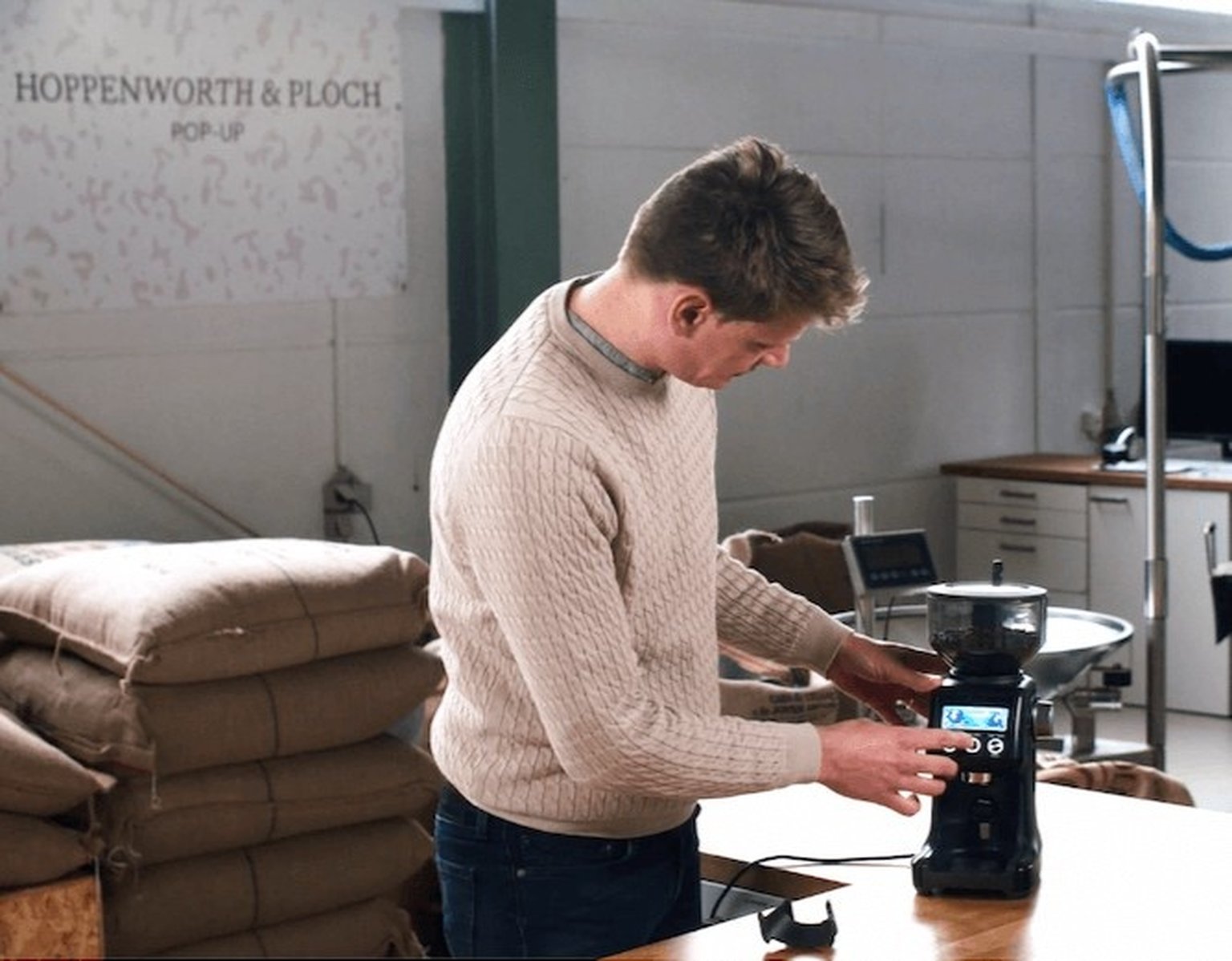 coffee expert, standing next to a coffee grinder
