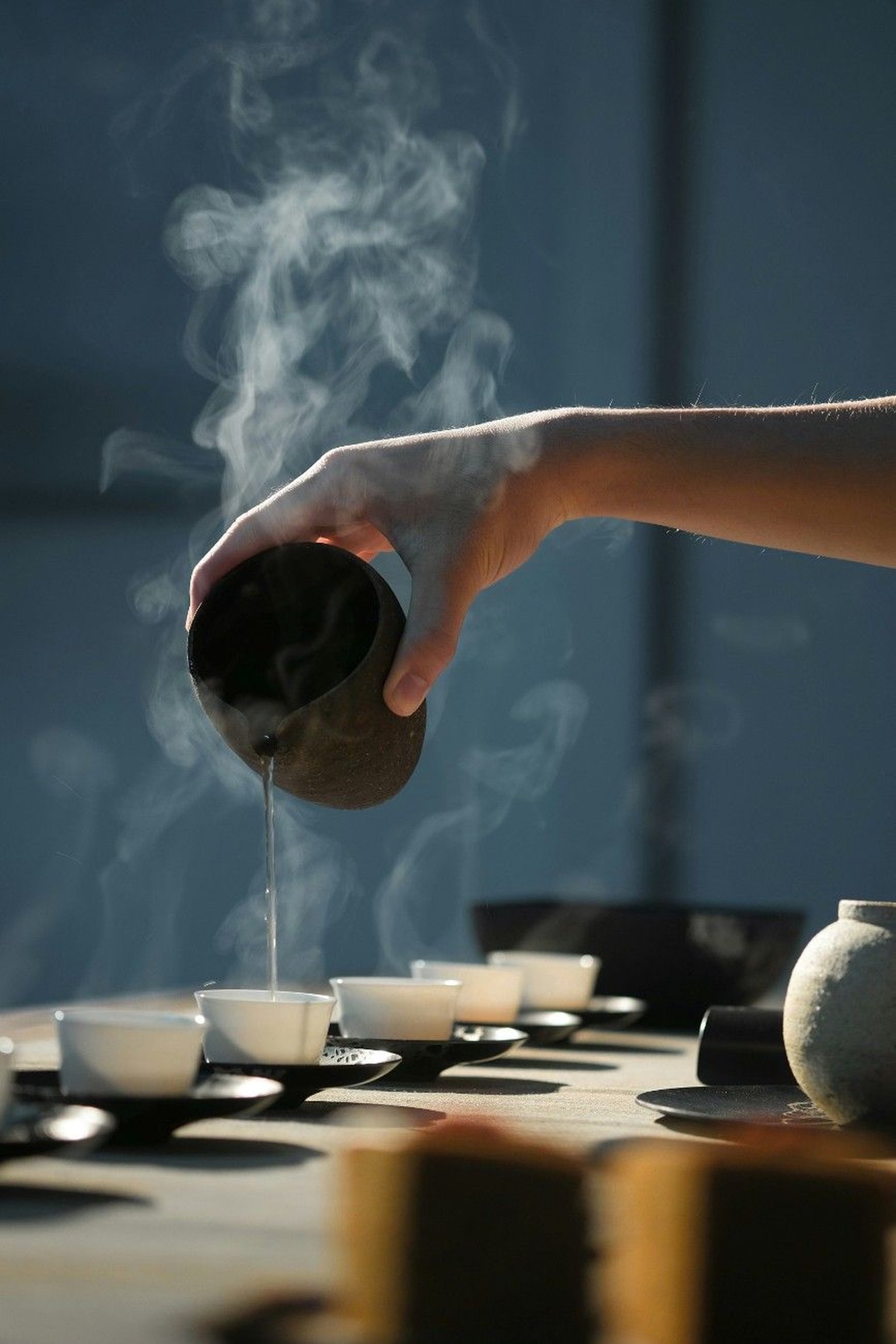 A selection of tea varieties displayed in bowls and cups on a wooden surface.
