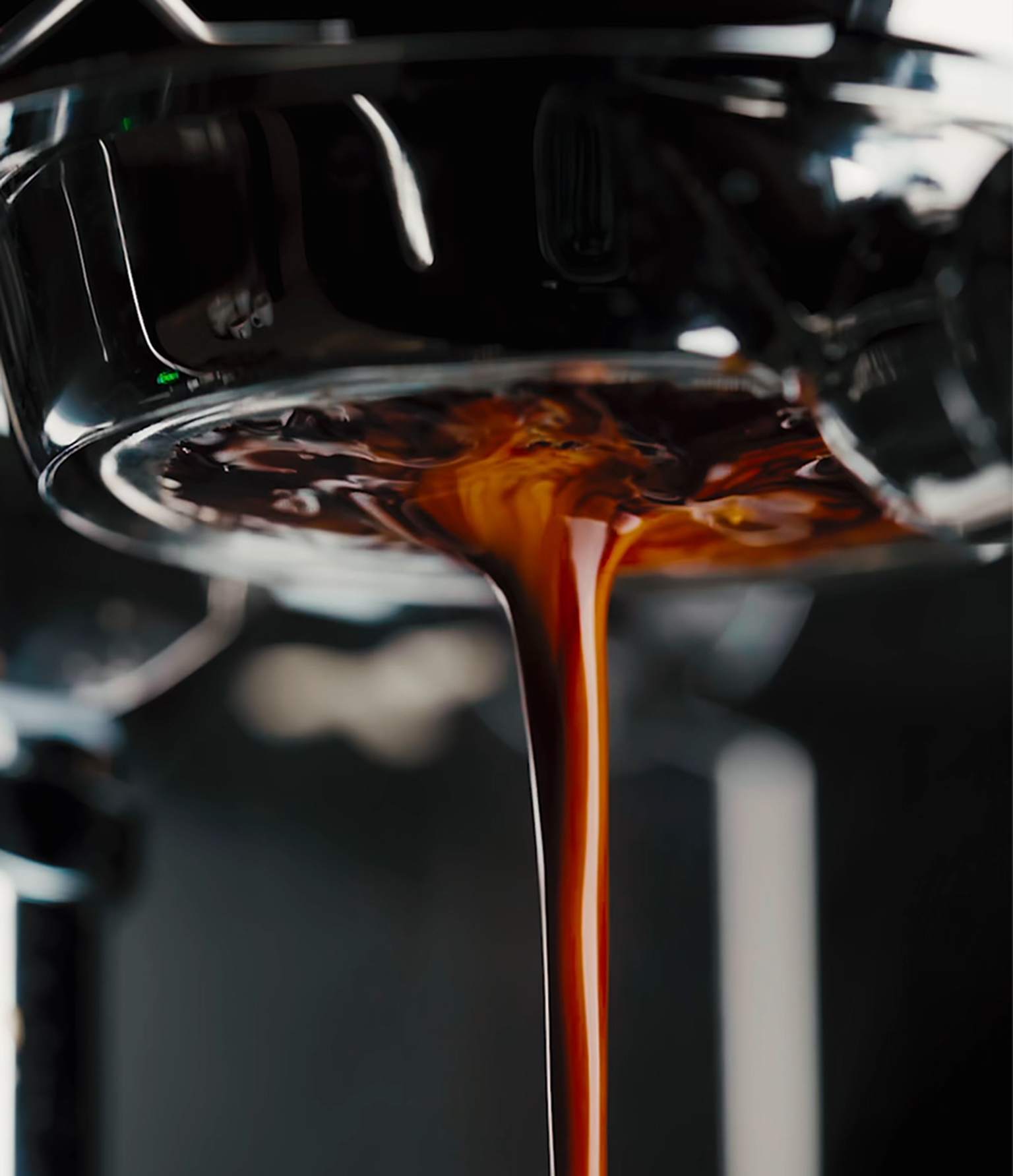 Rich, dark espresso with golden crema flowing from a coffee machine's portafilter, emphasizing a fresh, high-quality brew.