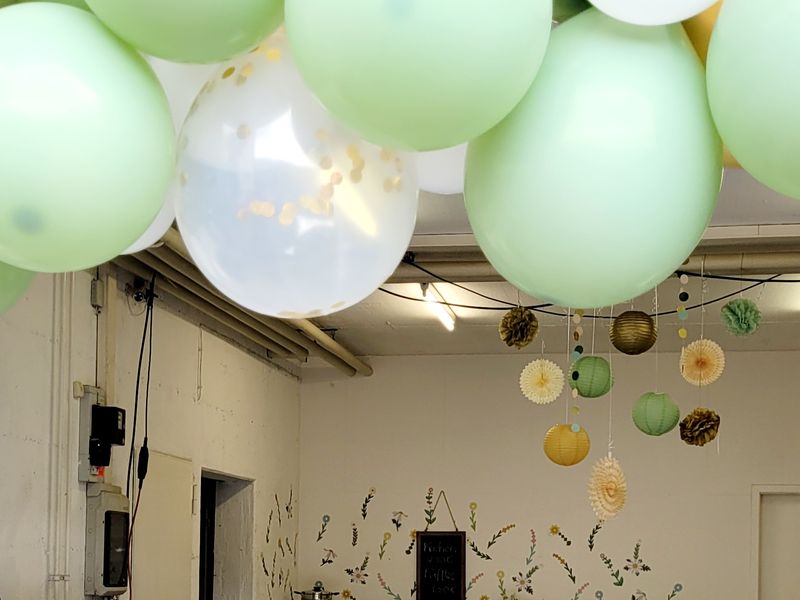 Fröhlich dekoriert mit Luftballons und Papierrosetten, bunten Blumen und leckerem Kuchenbüffet
