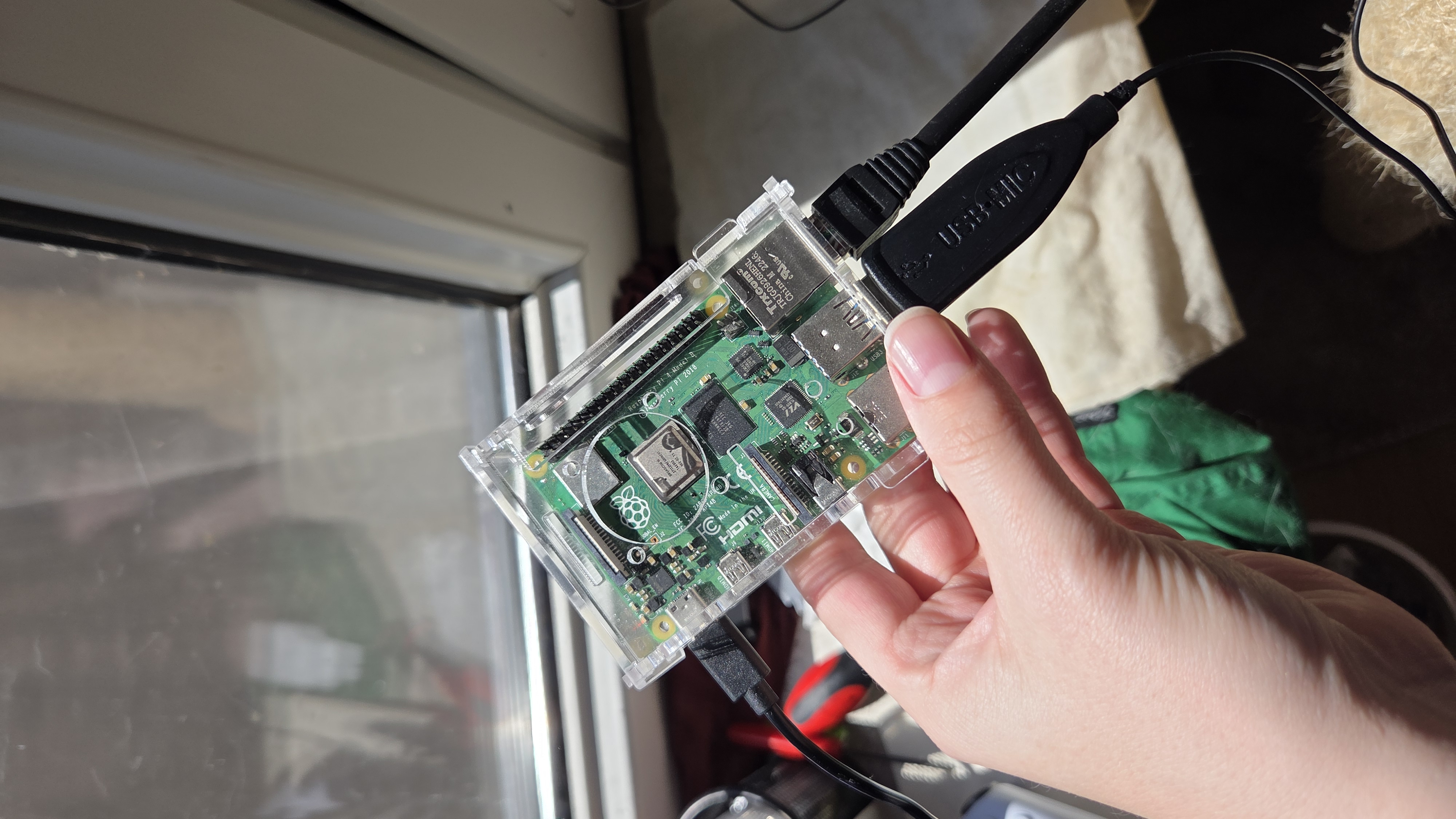 Hand holding a Raspberry Pi with Ethernet and USB plugged in
