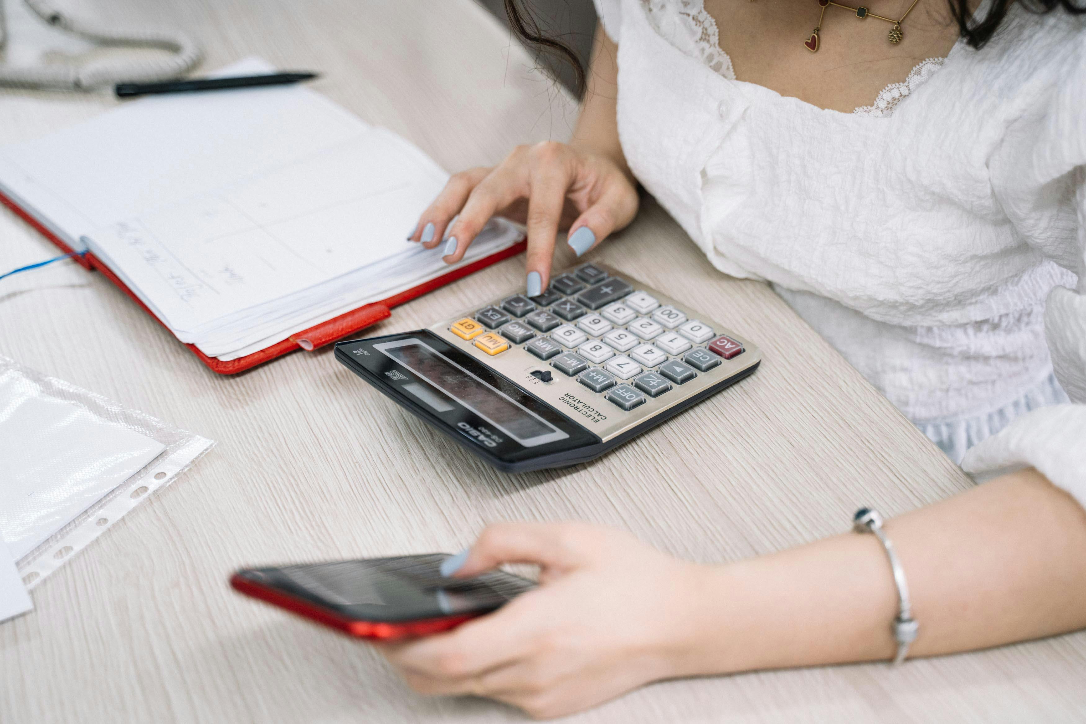 HVAC contractor calculating service pricing and estimates on laptop with calculator