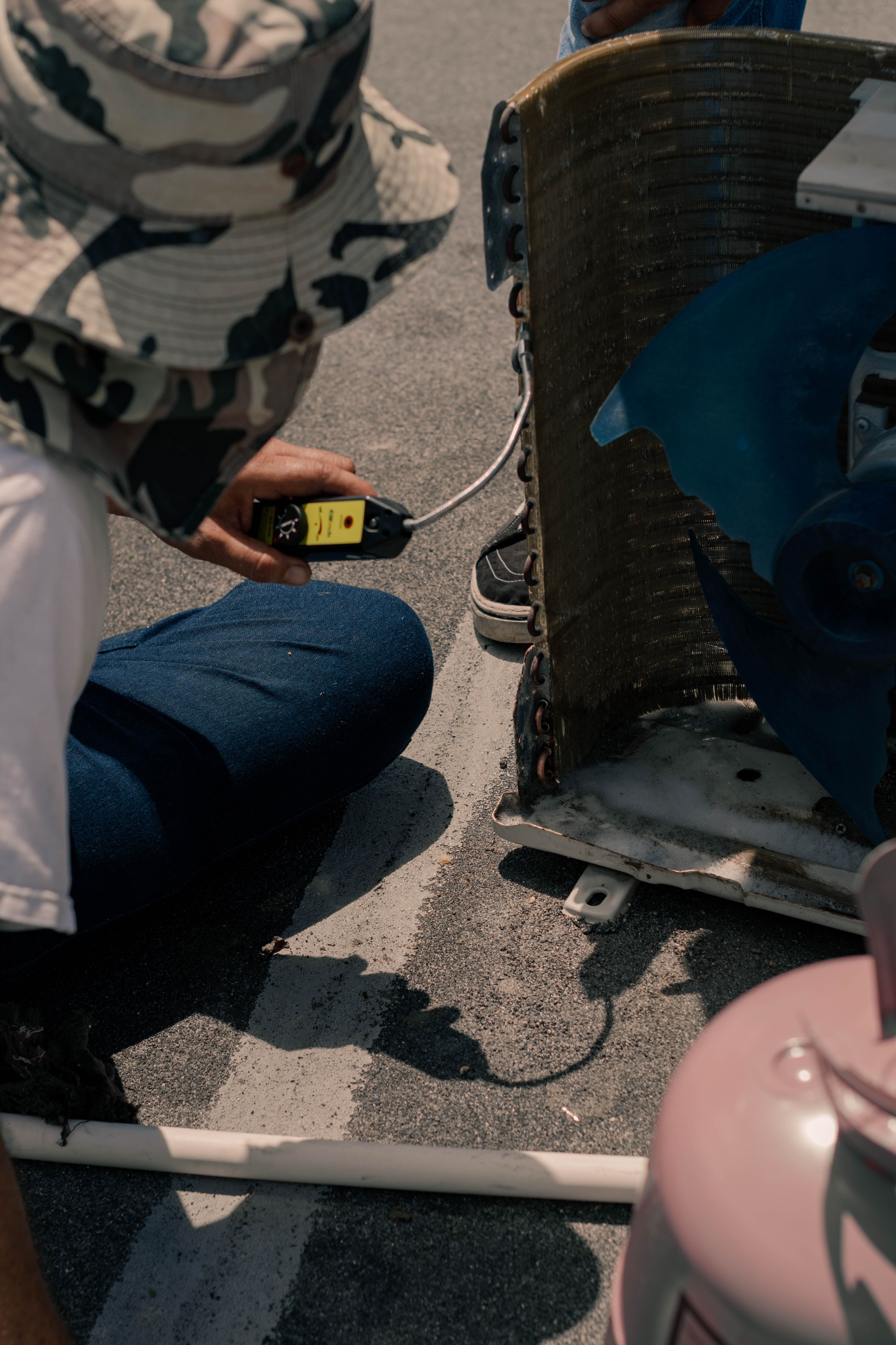 HVAC technician wearing safety gear while inspecting an air conditioning unit