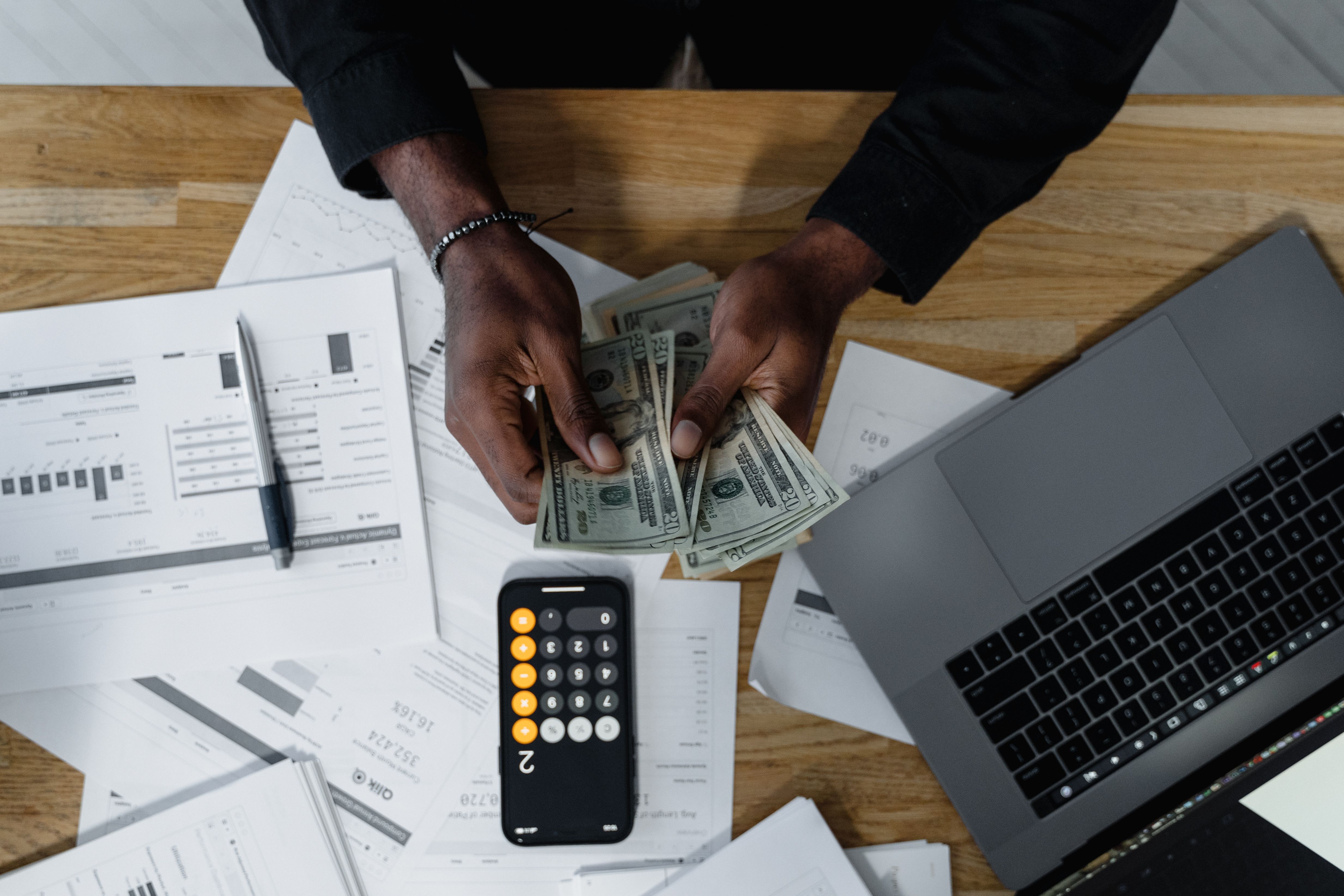 HVAC contractor analyzing job costing and profit margins on a laptop with service reports