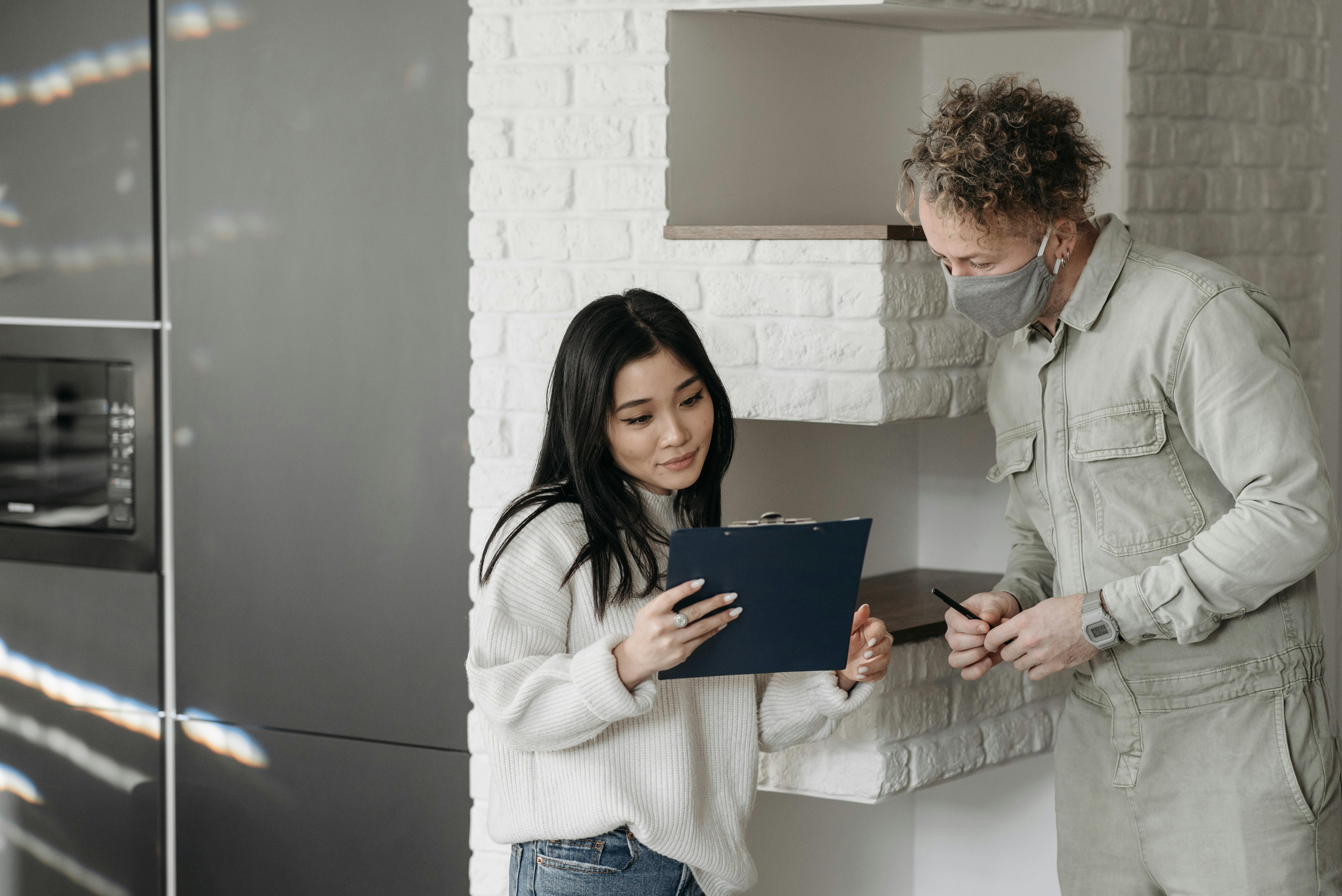 two people discussing HVAC technician presenting a flat rate repair estimate to a homeowner