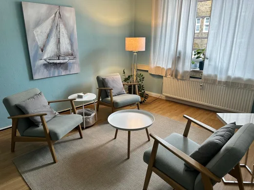 Ruhiger Gesprächsraum der Praxis in Kiel mit Sesseln und Segelbild