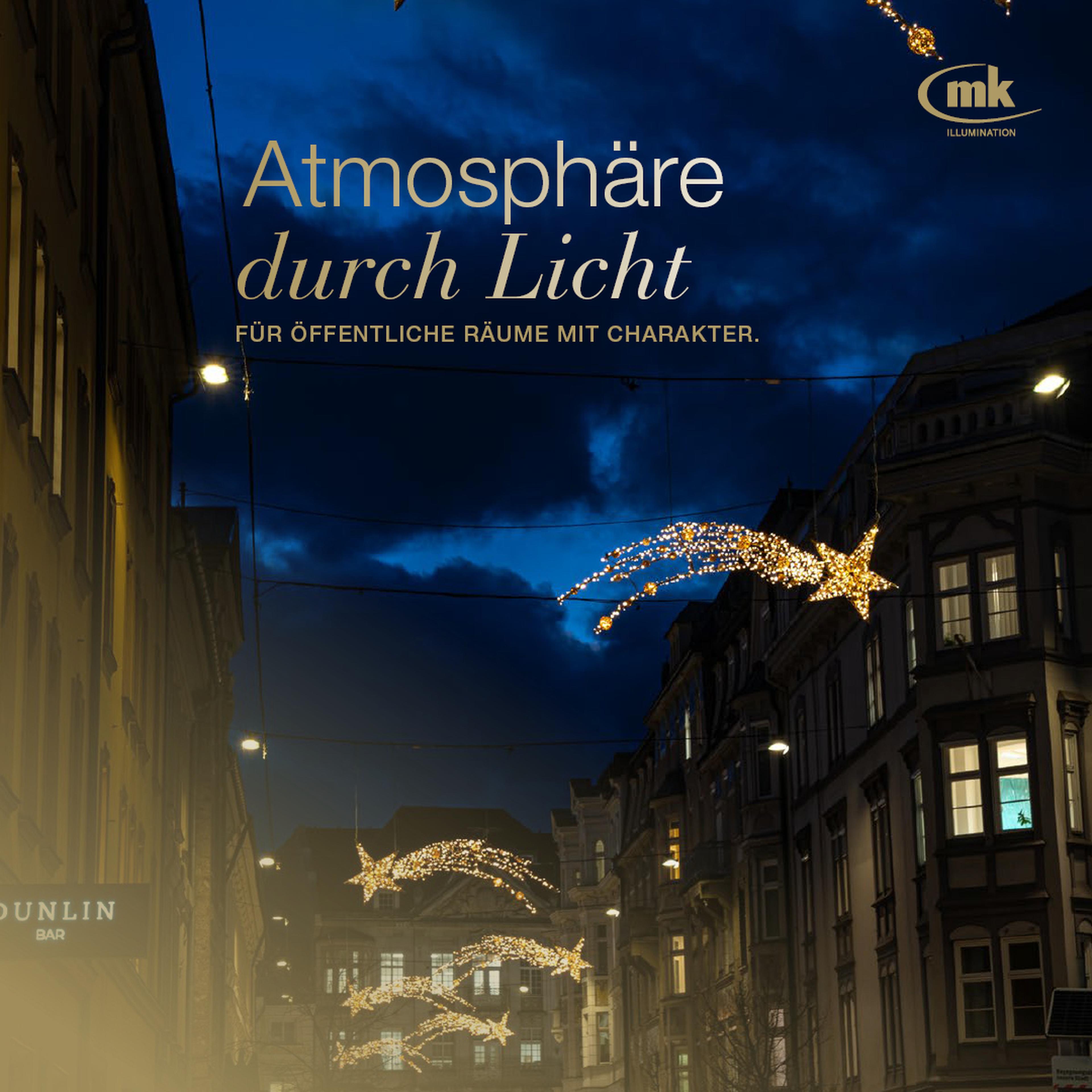 Straße mit dekorativen Lichterketten, die Sterne und Kometen darstellen, bei Abenddämmerung, erzeugen eine festliche Atmosphäre.