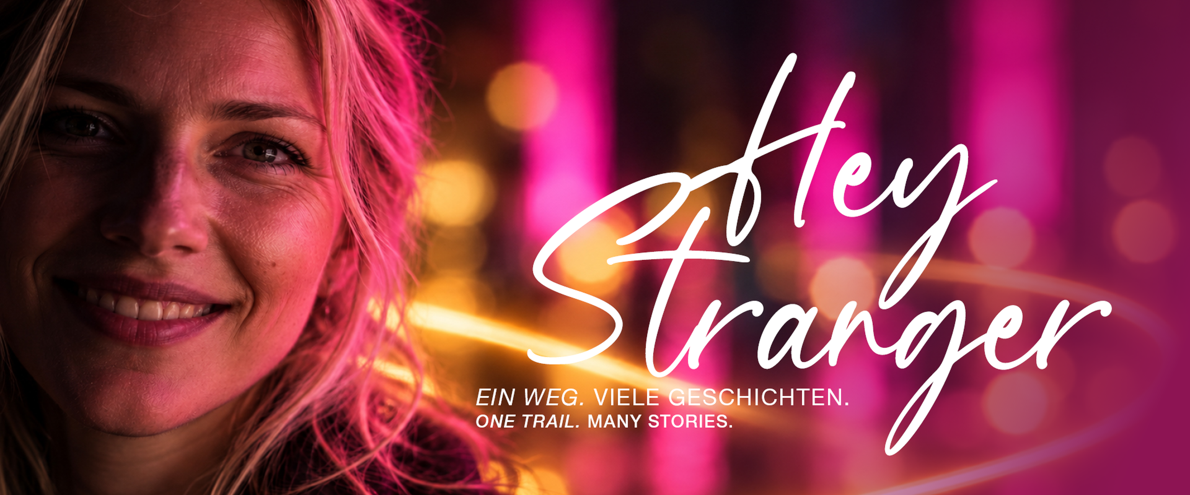 Frau lächelt vor verschwommenem, pink-beleuchtetem Hintergrund mit Text "Hey Stranger. Ein Weg. Viele Geschichten."