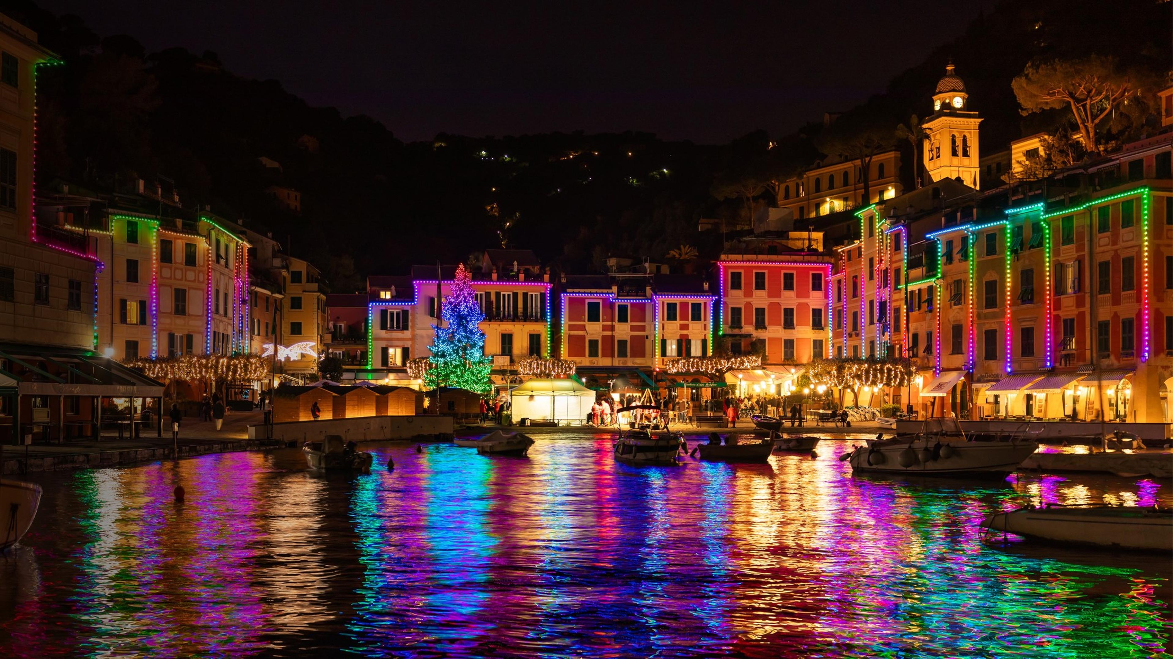 Stadt bei Nacht, festlich beleuchtet mit bunten Lichtern, die sich im Wasser spiegeln, verleiht eine zauberhafte Atmosphäre.