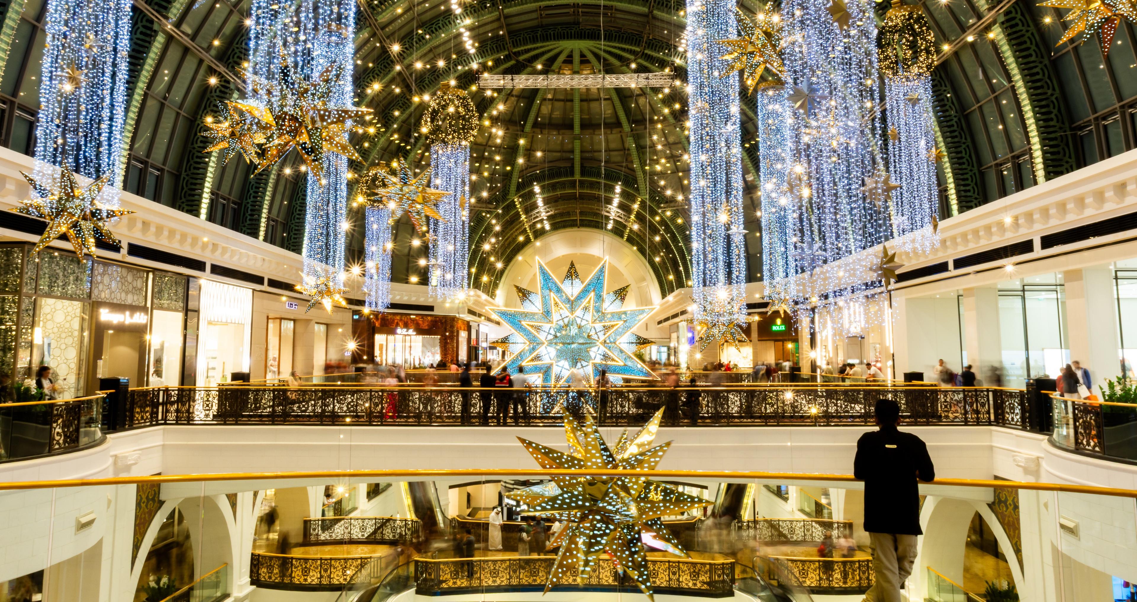 Lichterinstallation mit goldenen Sternen und blauen Lichtvorhängen in einem Einkaufszentrum.