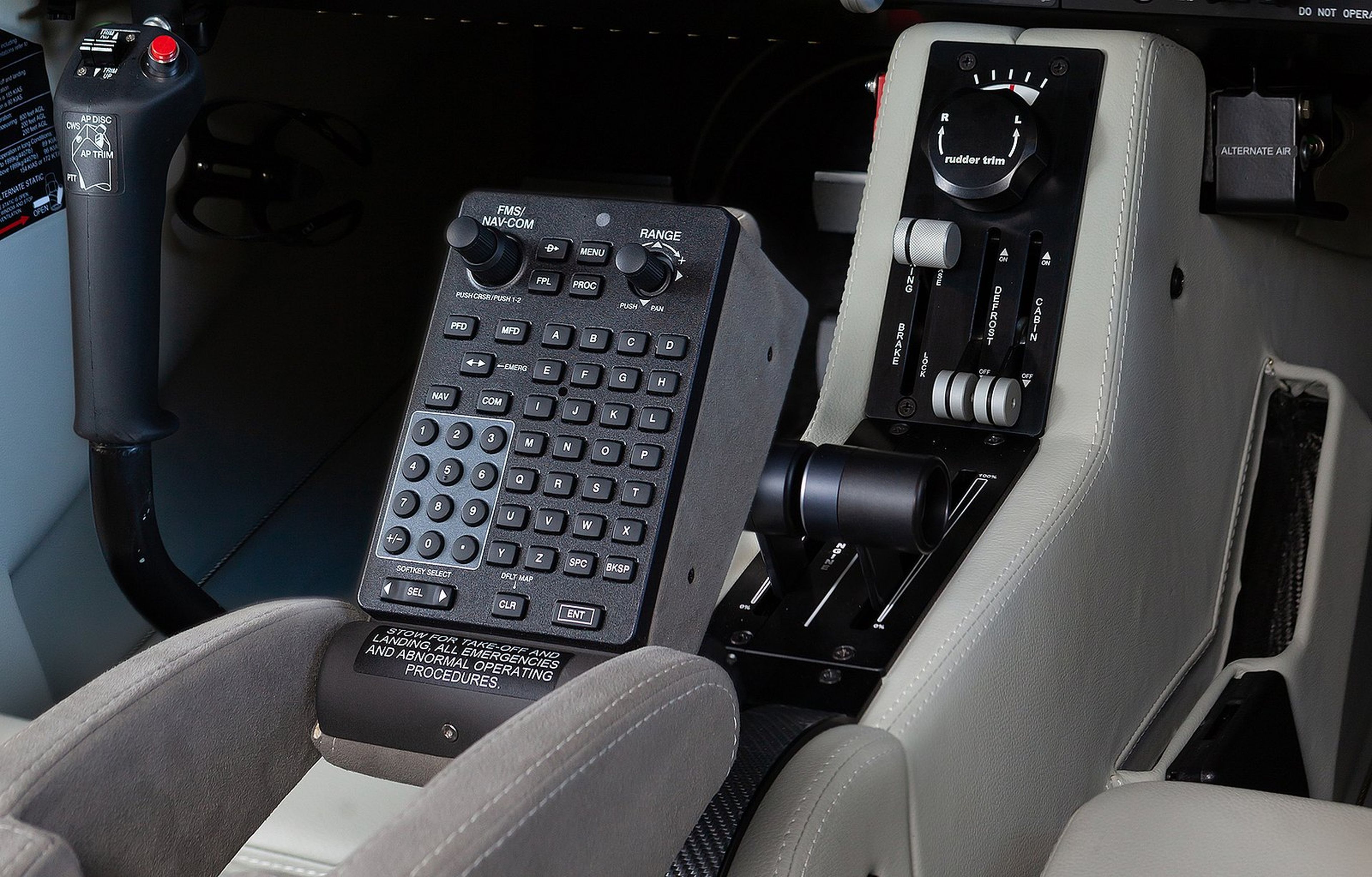 Cockpit controls featuring a keypad, joystick, and various switches and dials, designed for aircraft navigation and operation.