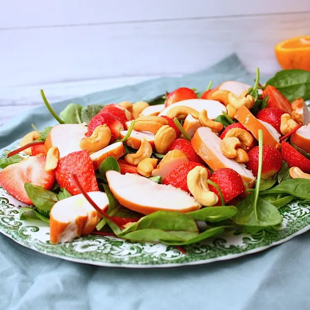 Salade met gerookte kip, aardbeien en sinaasappeldressing