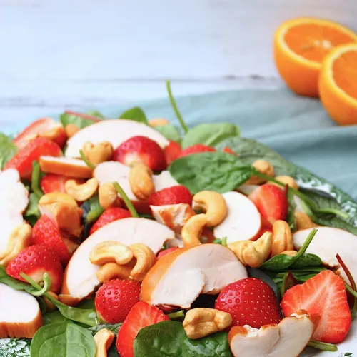 Salade met aardbeien, gerookte kip en sinaasappeldressing