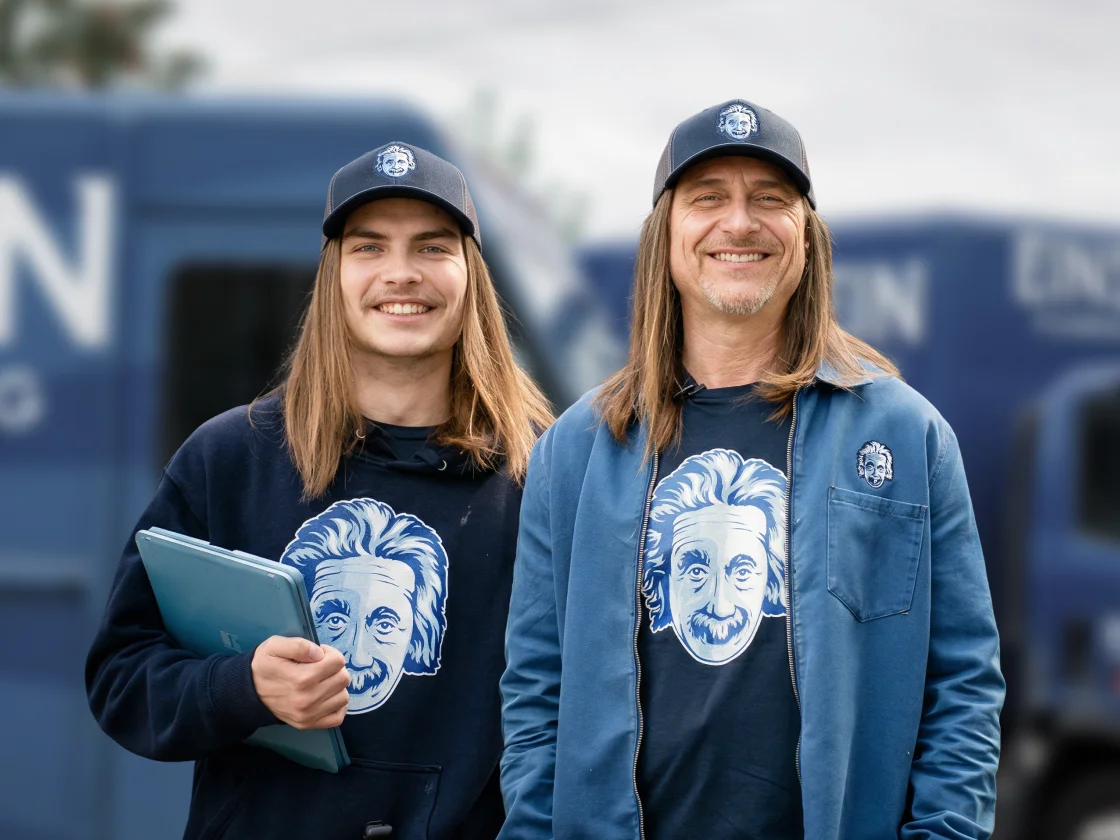 Dan and Wyatt Johnson of Einstein Pros in front of their branded service vans