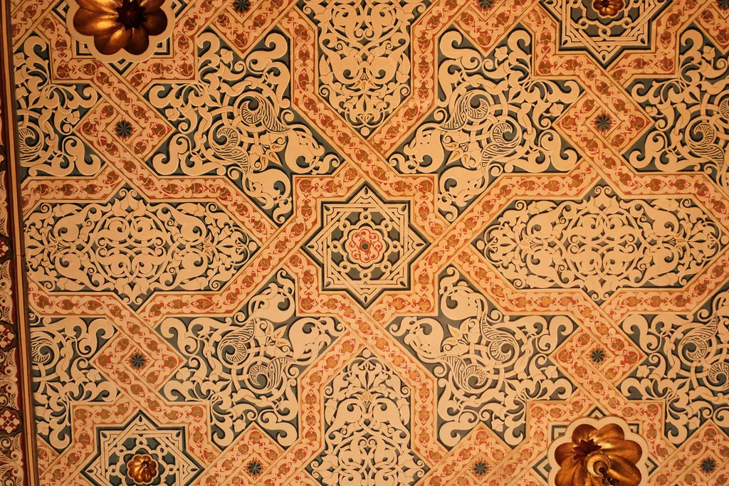 Detailreiche, geometrische Wanddeko mit floralen Mustern und arabesken Ornamenten in Beige, Rosa und Dunkelgrün.
