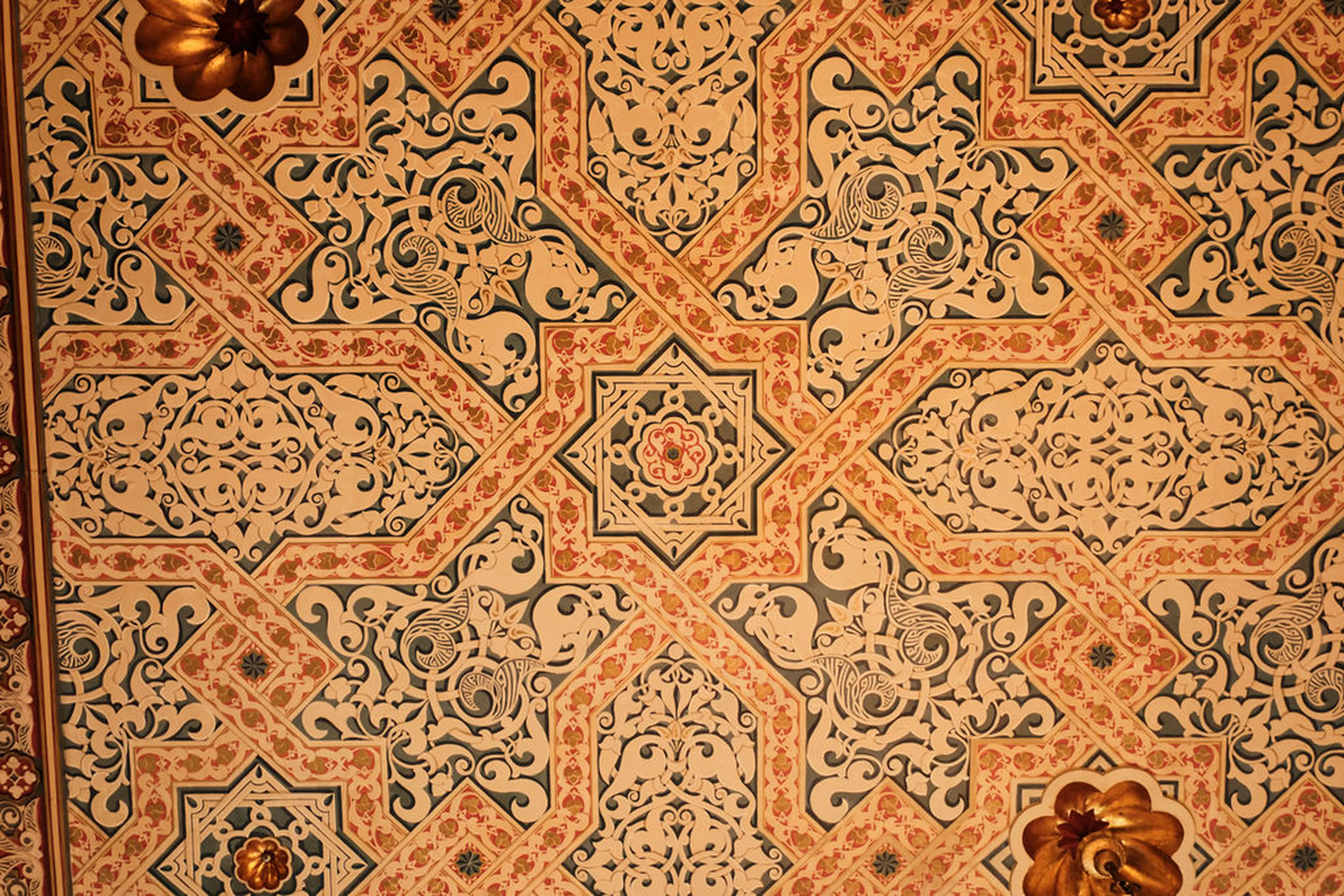 Detailreiche, geometrische Wanddeko mit floralen Mustern und arabesken Ornamenten in Beige, Rosa und Dunkelgrün.