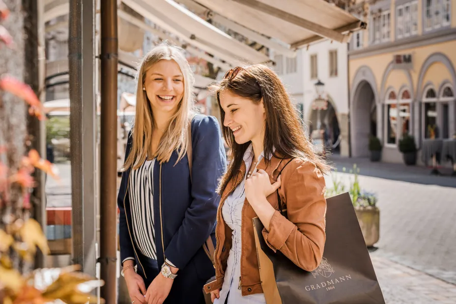 two female friends shopping in Constance with a shopping bag