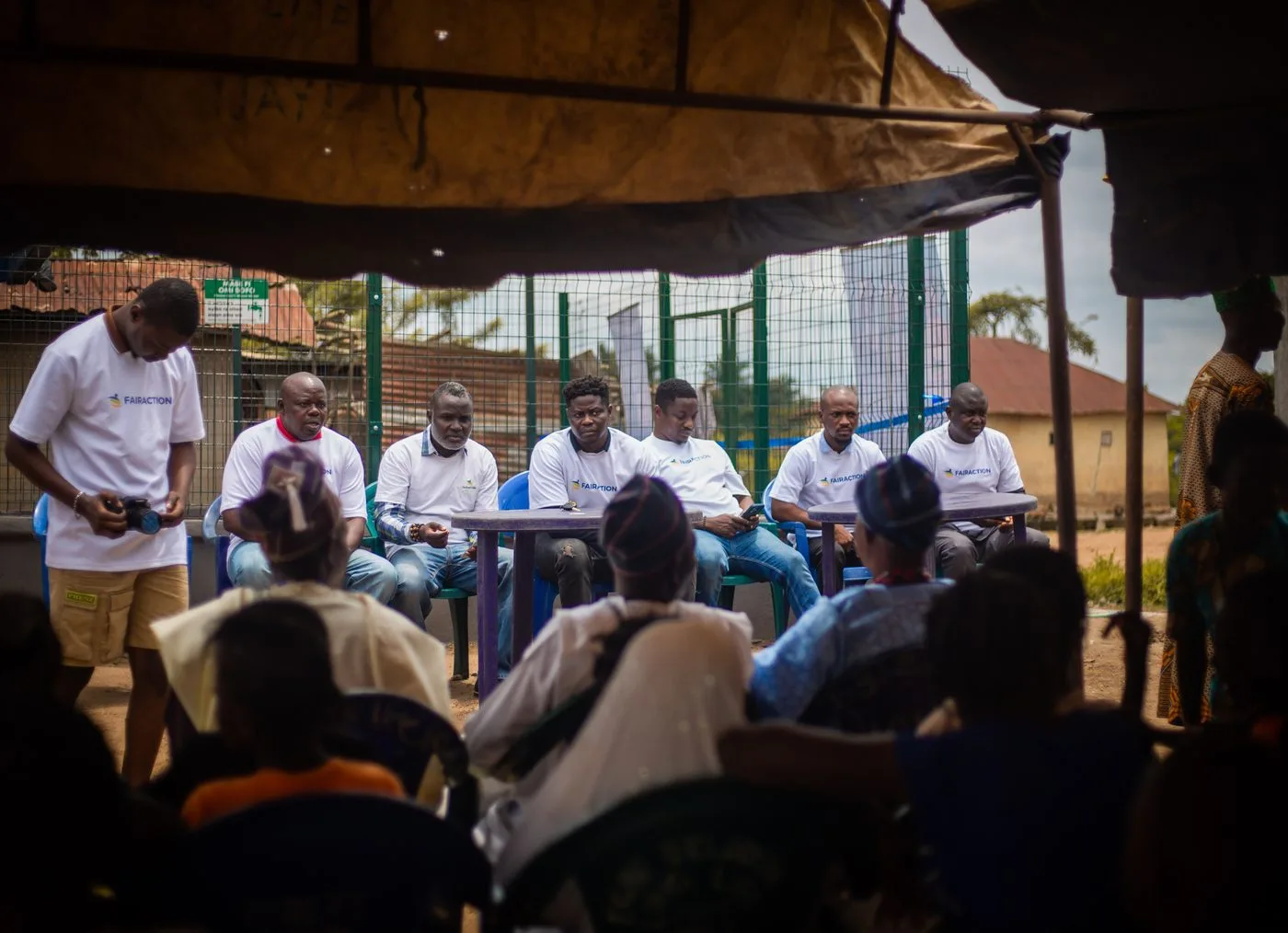 A community meeting at a Fairaction operational site, with team members in Fairaction shirts seated alongside community members. Photo courtesy of Fairaction Nigeria, used with informed consent.